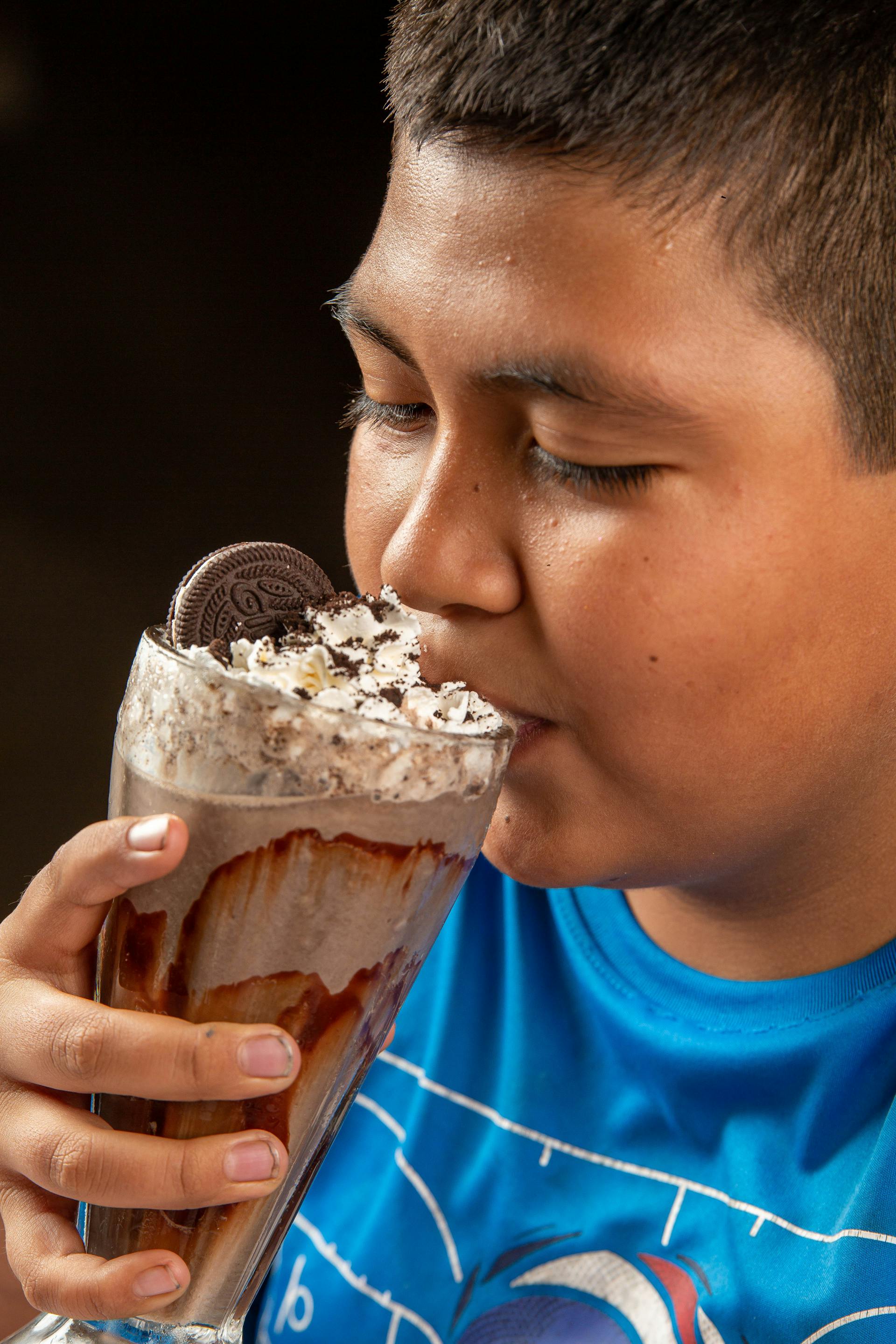 Un niño bebiendo batido de Oreo | Fuente: Pexels