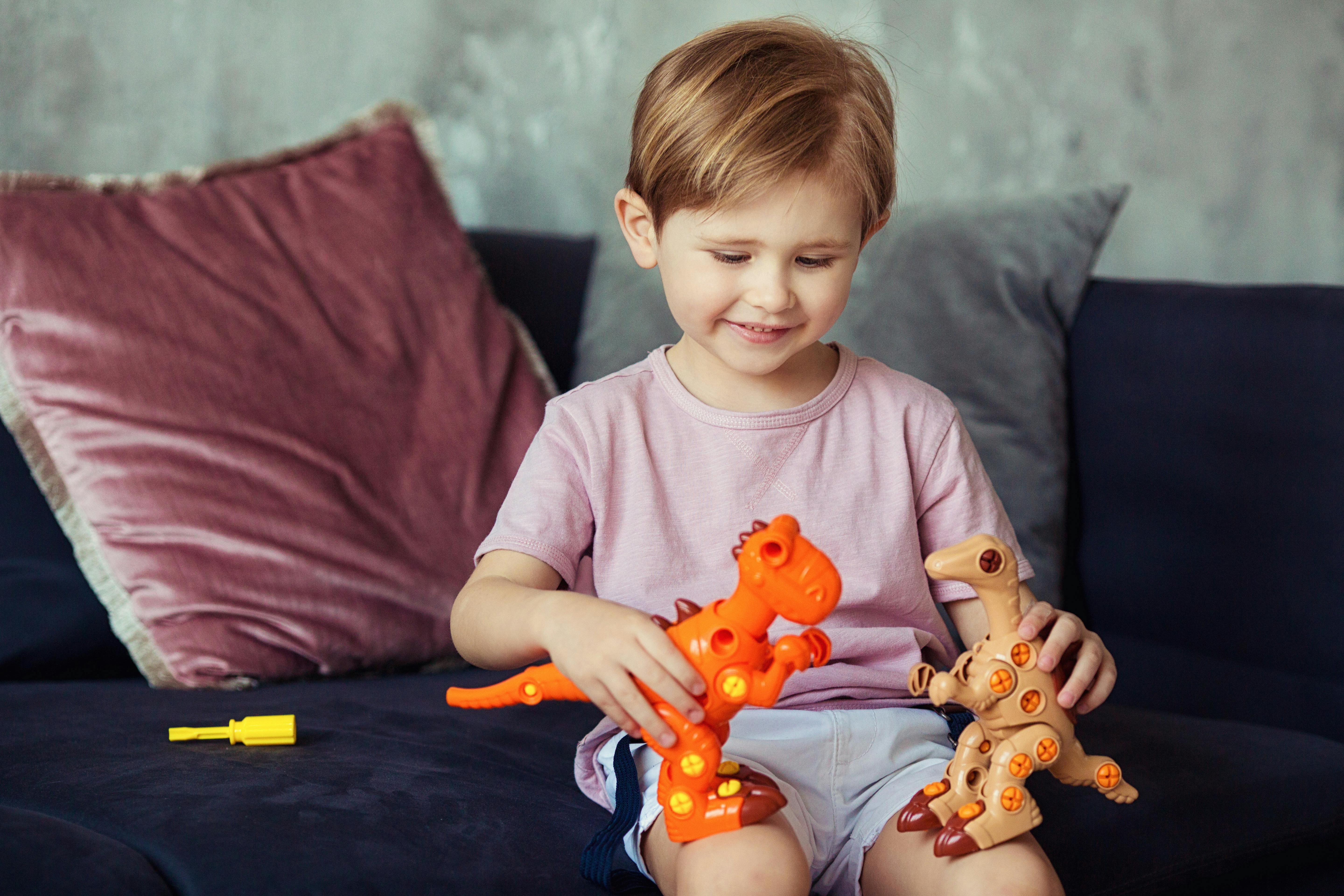 Un niño jugando con juguetes de dinosaurios | Fuente: Pexels