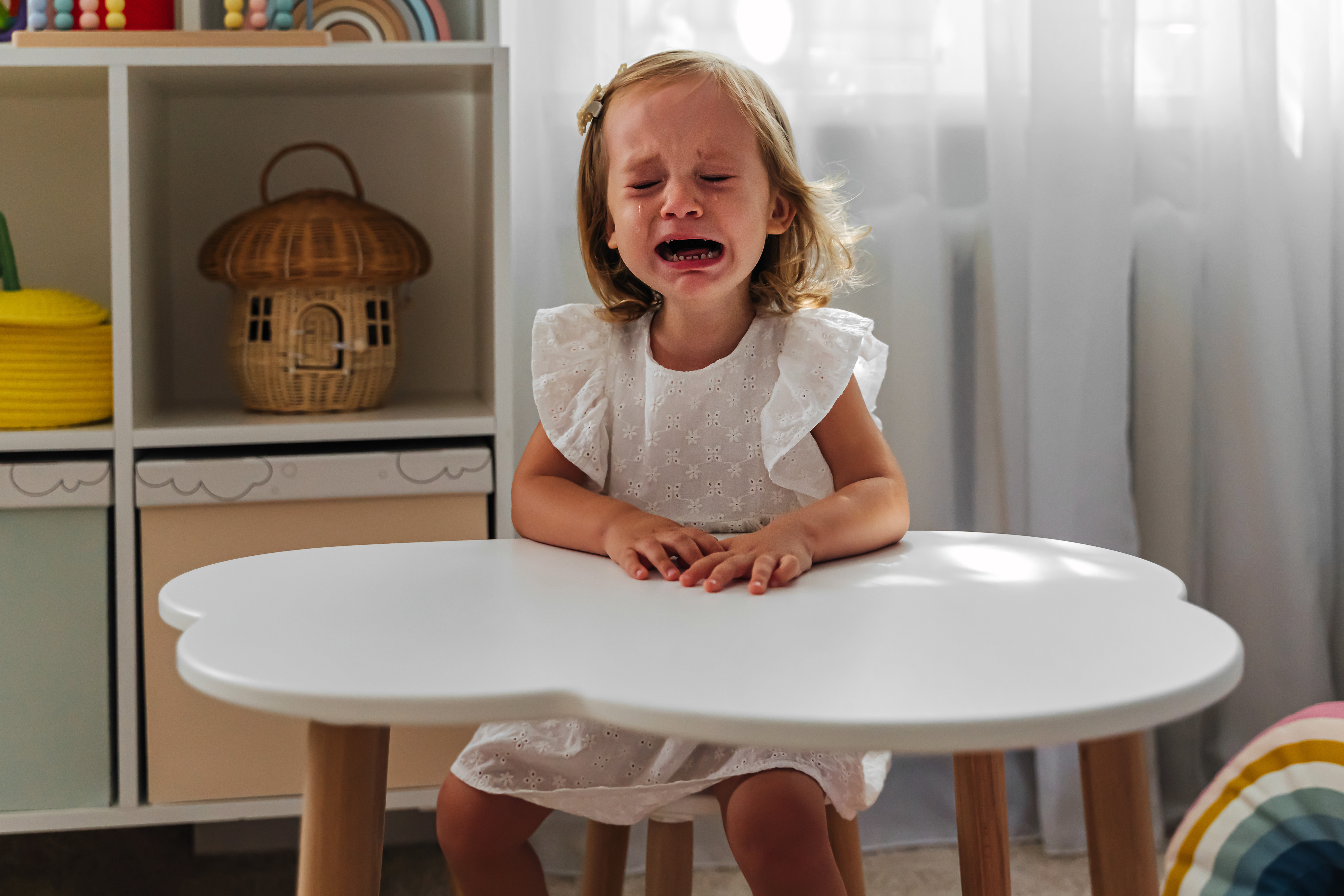 Una niña llorando sentada a la mesa en su clase | Foto: Getty Images