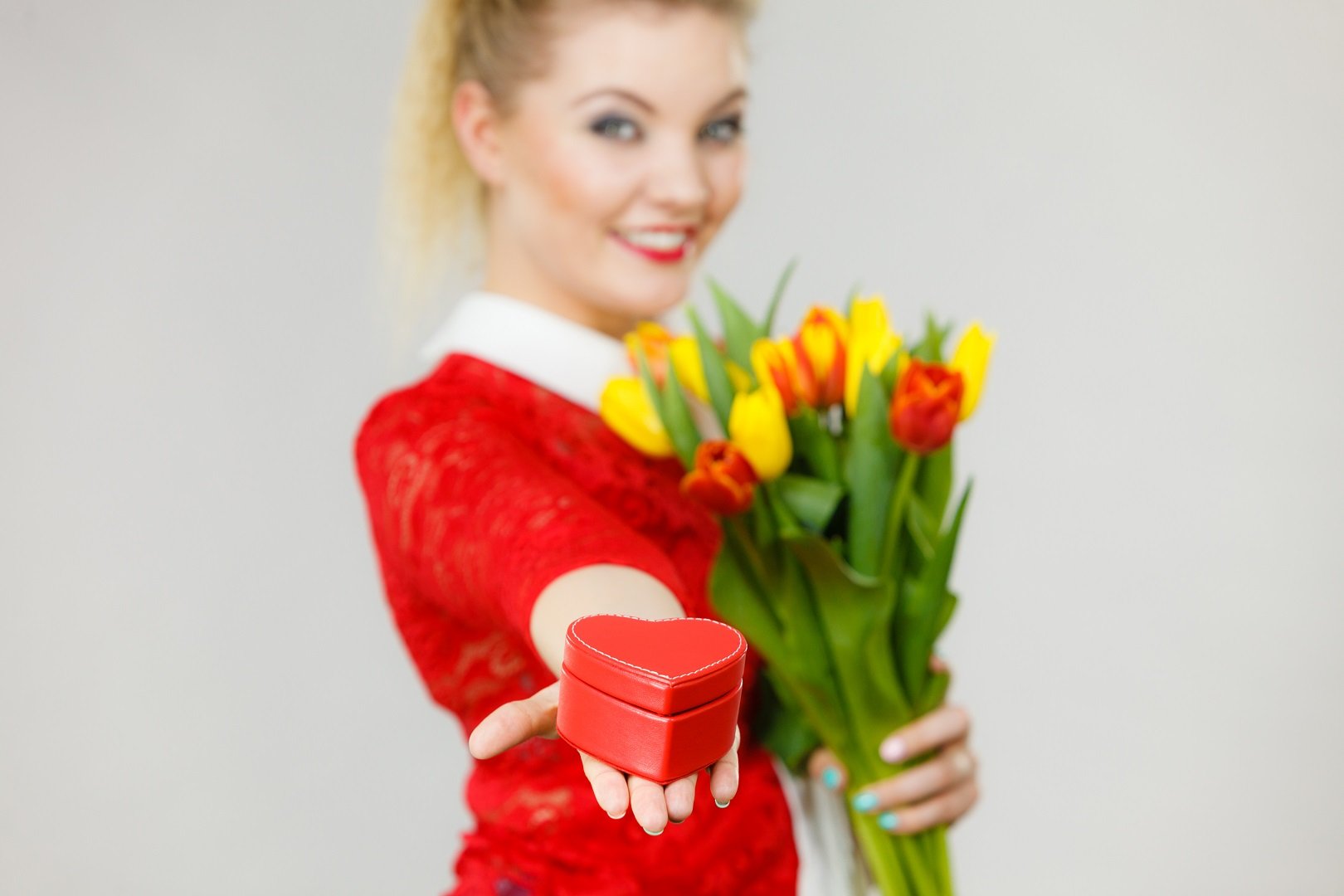 Mujer con flores y regalo || Fuente: Shutterstock
