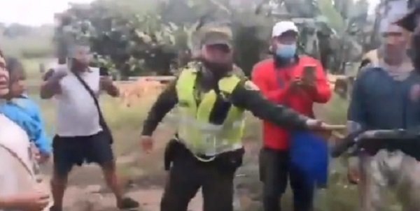 Captura del momento en que el patrullero Ángel Zúñiga entrega su arma para no participar en el desalojo de los campesinos. | Foto: Twitter/ Santialarconu