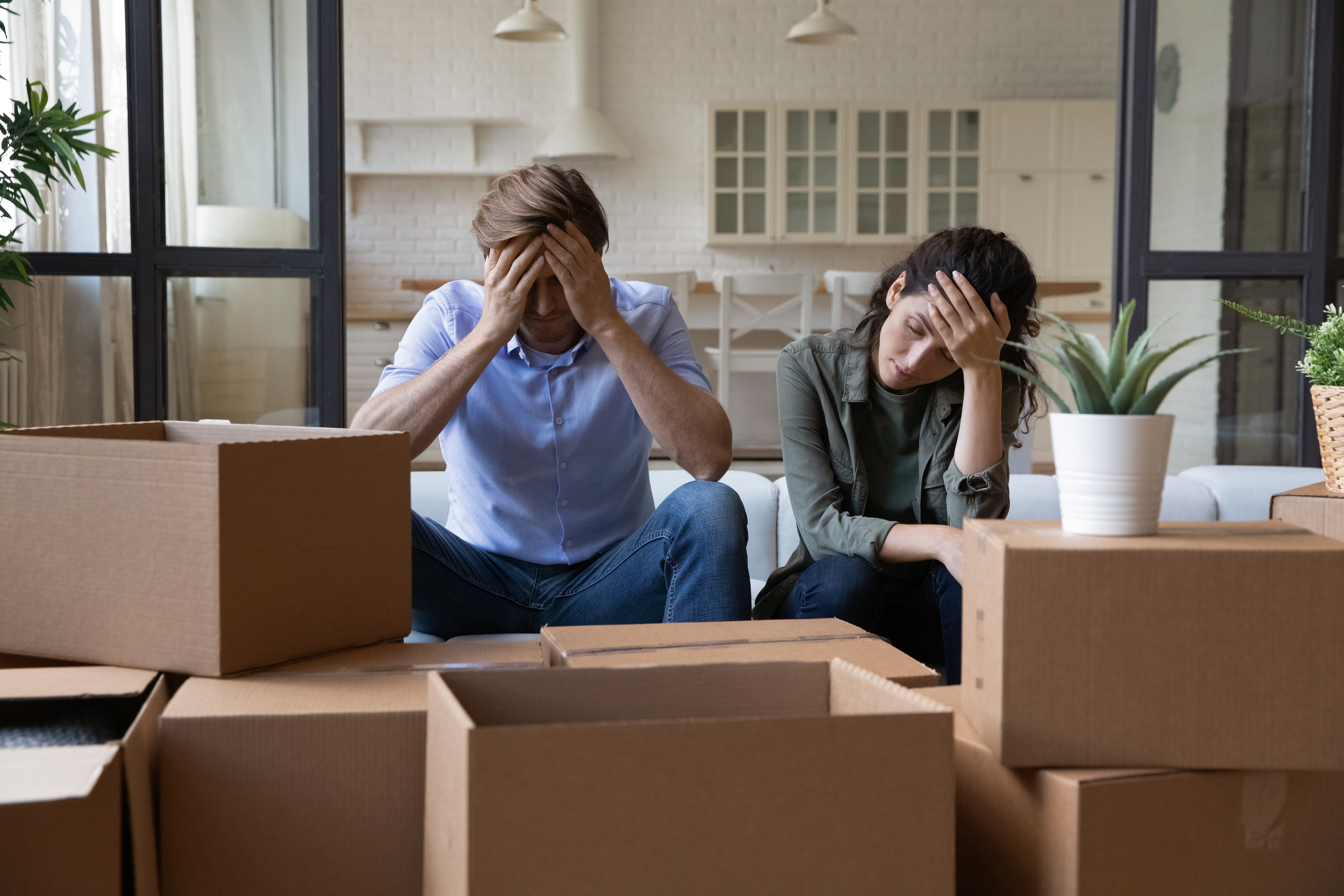 Pareja estresada rodeada de cajas | Foto: Shutterstock