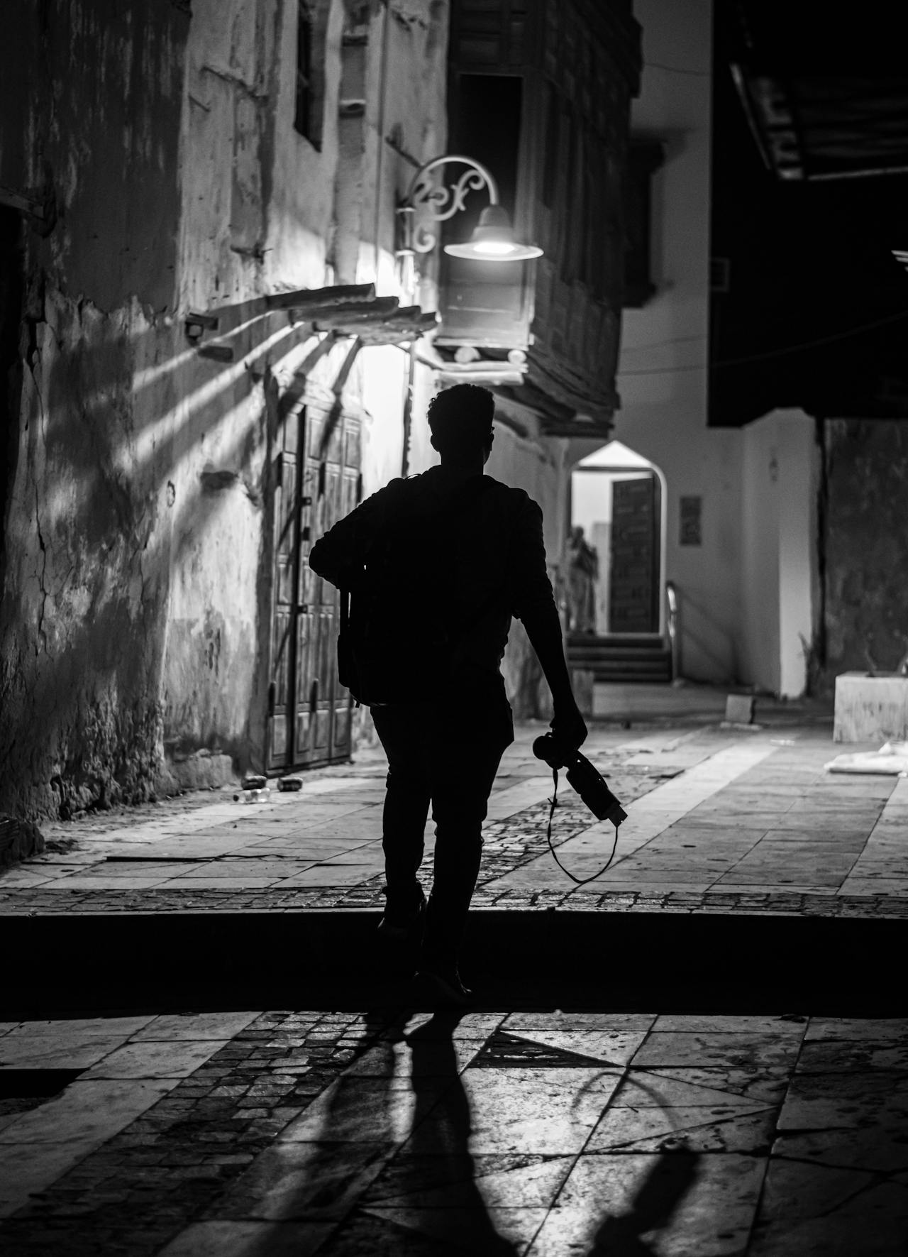 Un joven caminando por un callejón de noche | Fuente: Pexels