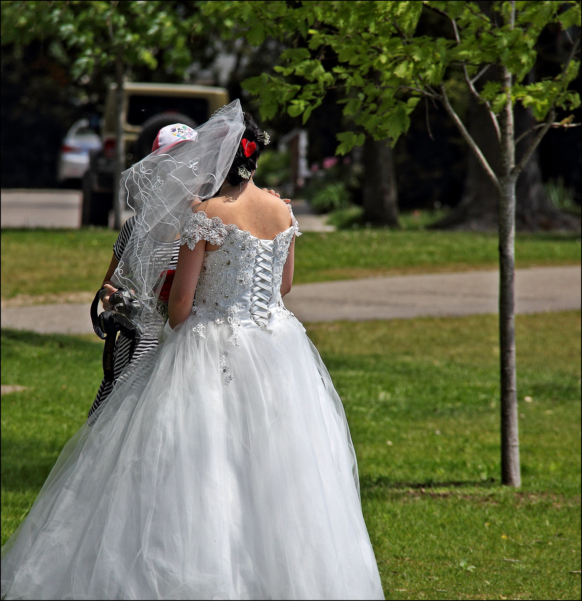 Vista trasera de una novia de pie al aire libre | Fuente: Flickr