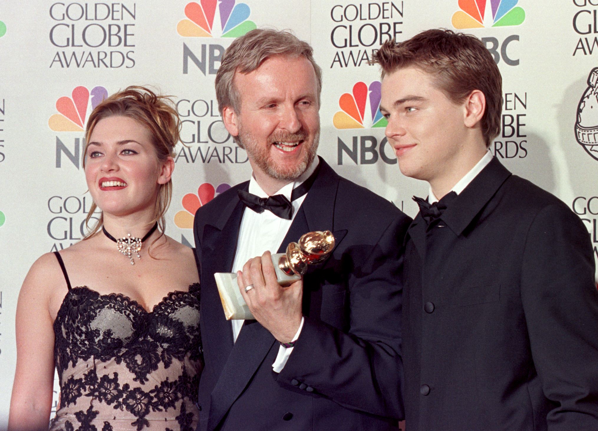 James Cameron (C), Kate Winslet (L) y Leonardo DiCaprio (R) posan para los fotógrafos después de que Cameron ganara el premio al Mejor Director por "Titanic" en la 55ª edición de los Globos de Oro en el Beverly Hilton el 18 de enero en Beverly Hills. | Fuente: Getty Images