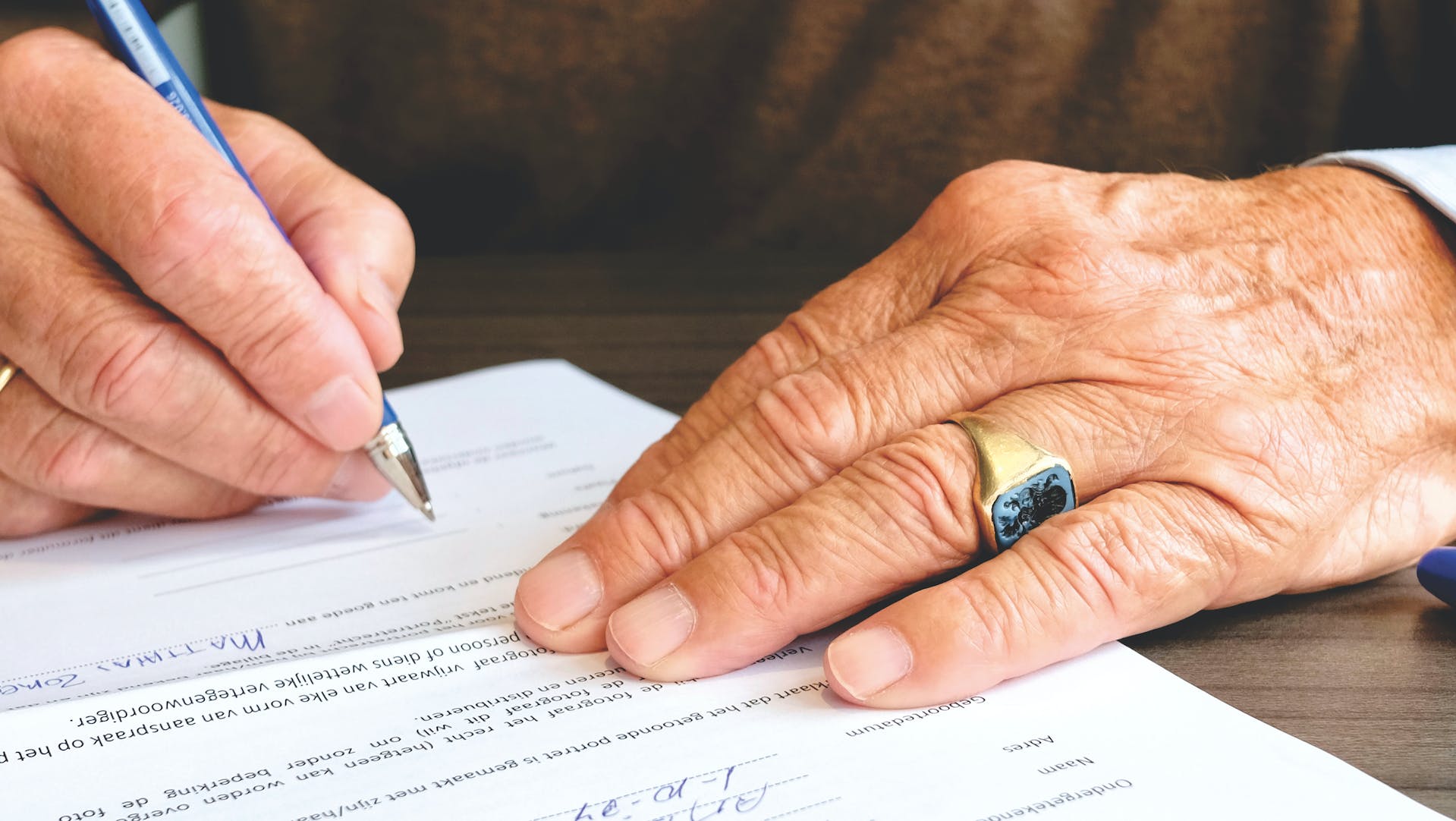 Un hombre firmando un documento | Fuente: Pexels