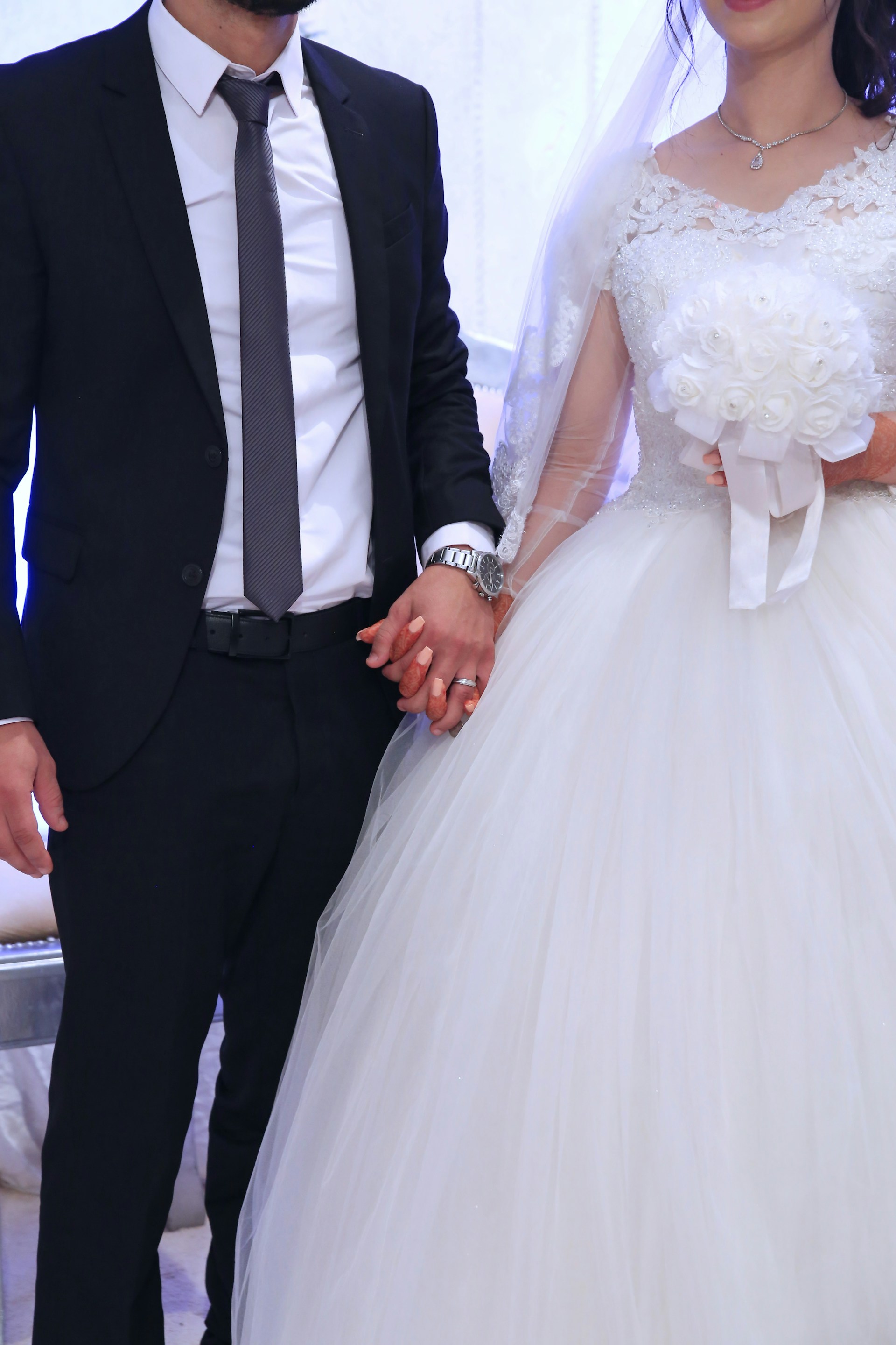 Una pareja de recién casados cogidos de la mano | Fuente: Unsplash