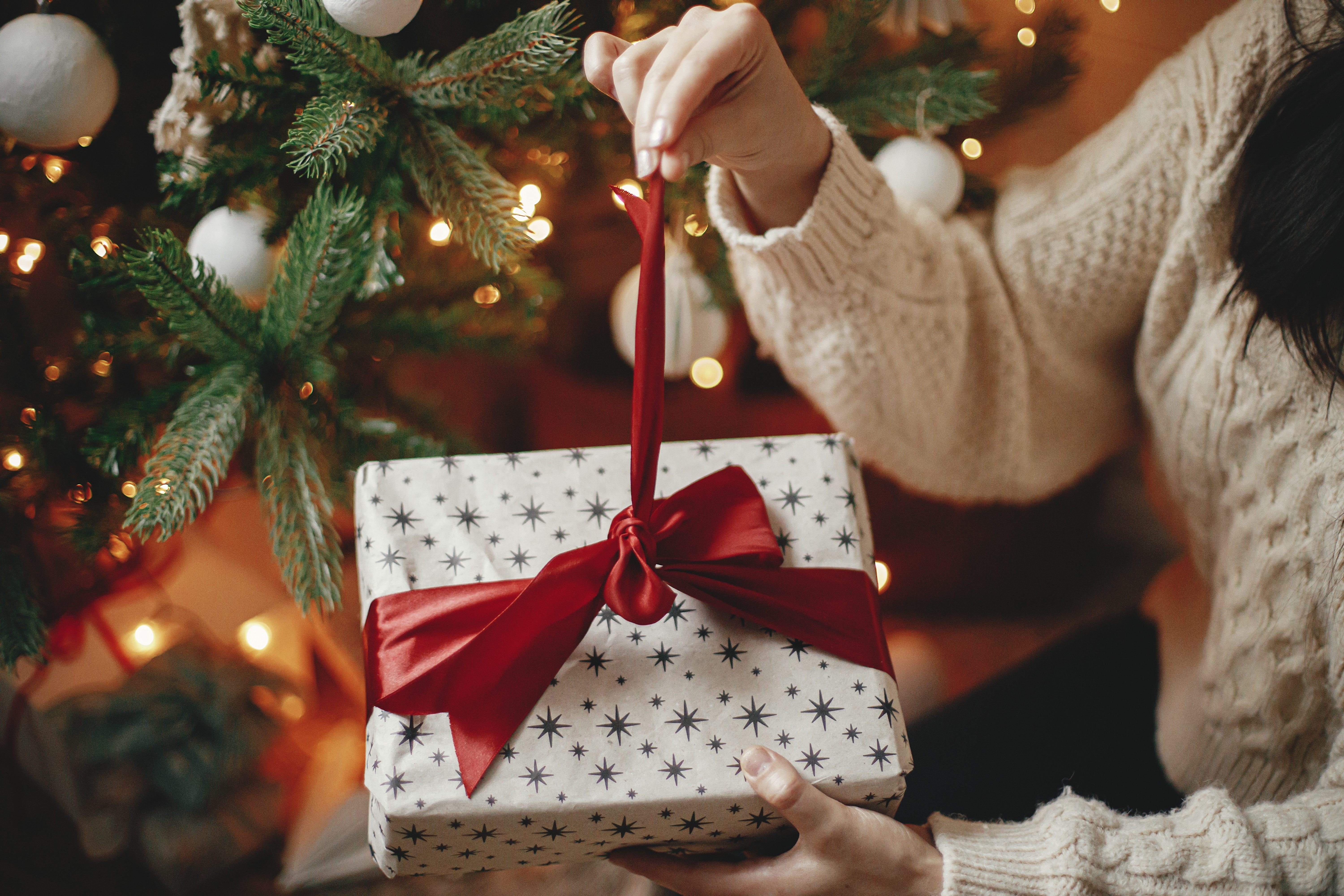 Persona abre un regalo de Navidad | Foto: Shutterstock