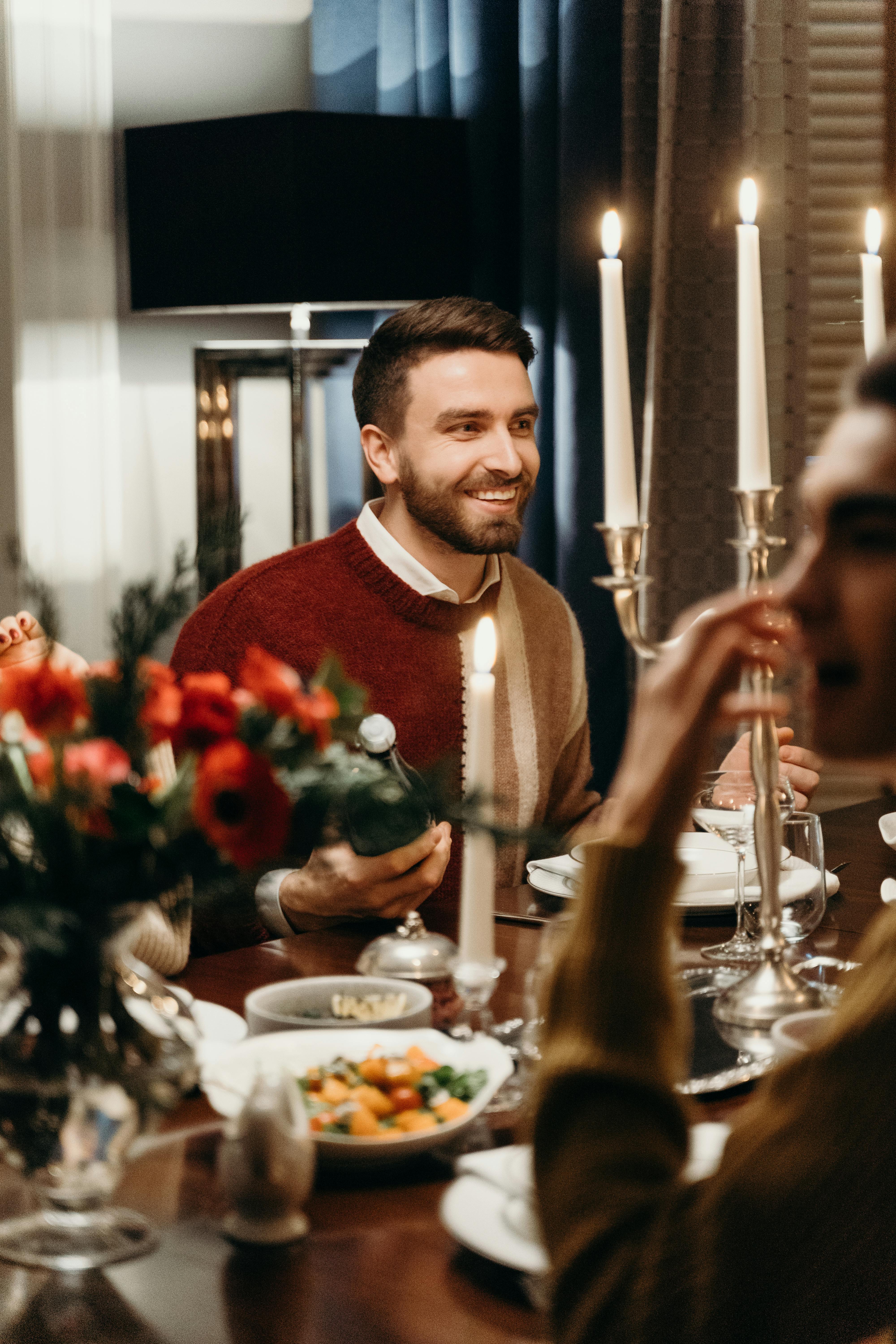 Un hombre sonriente en la mesa | Fuente: Pexels