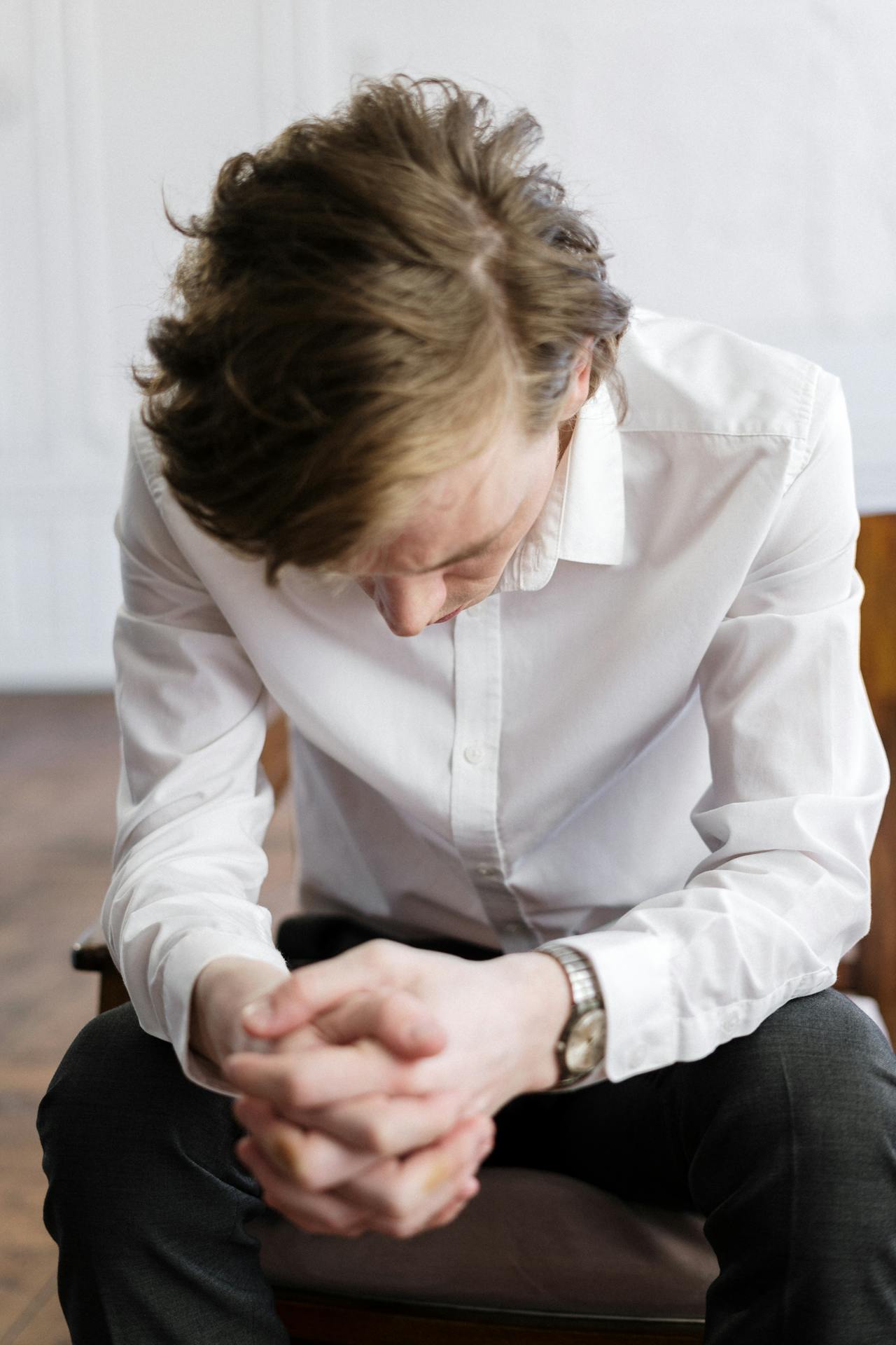Un hombre triste sentado en una silla | Fuente: Pexels