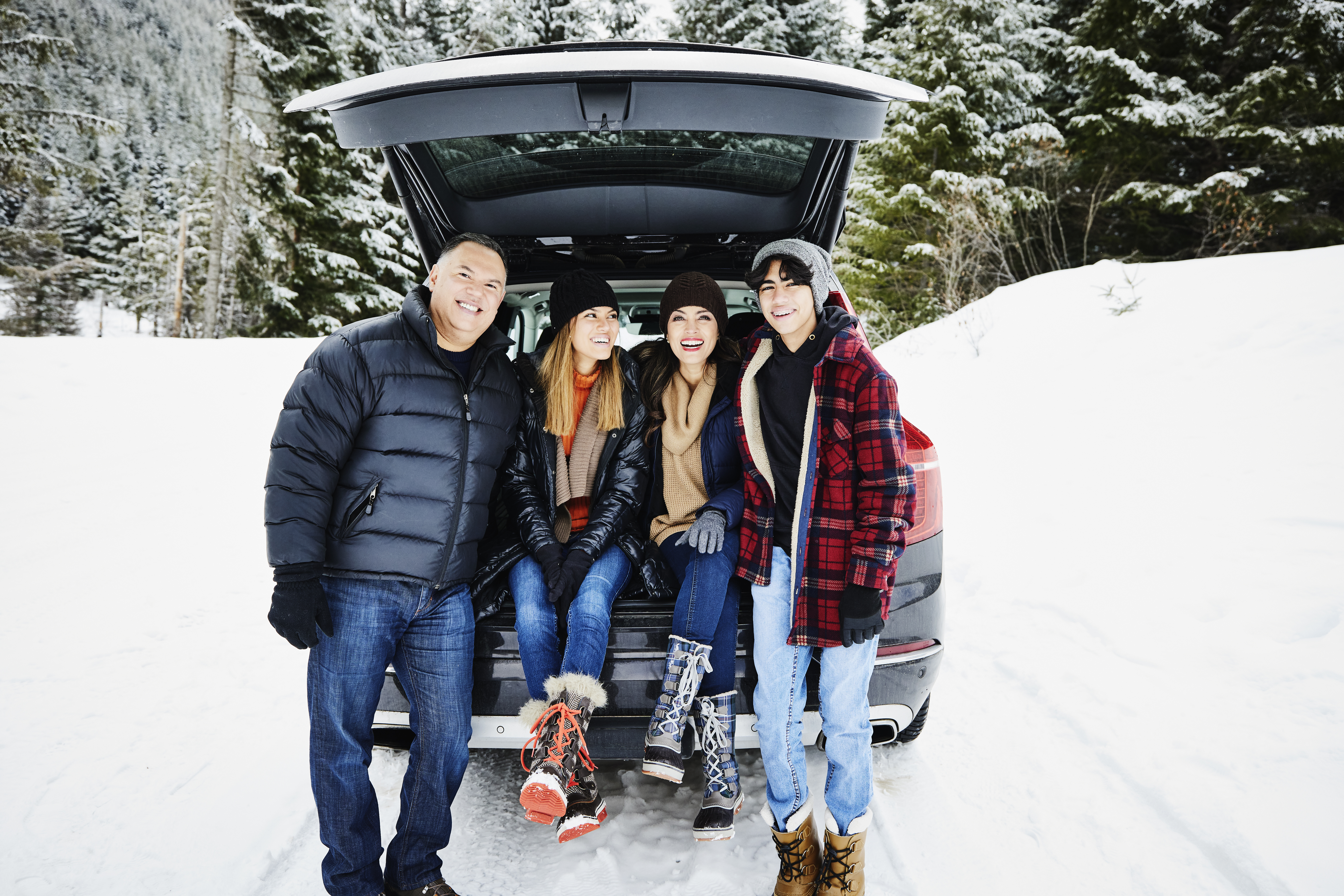Una familia sentada en el maletero de su automóvil en la nieve | Foto: Getty Images