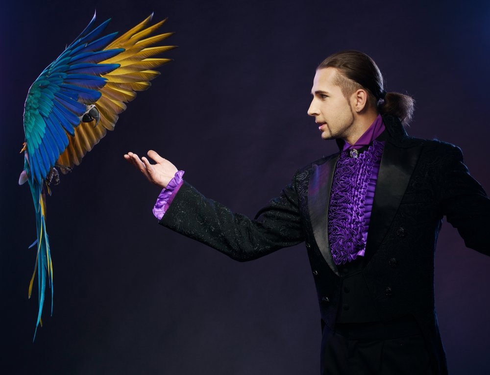 Una foto de un mago en el escenario con un loro. | Foto: Shutterstock