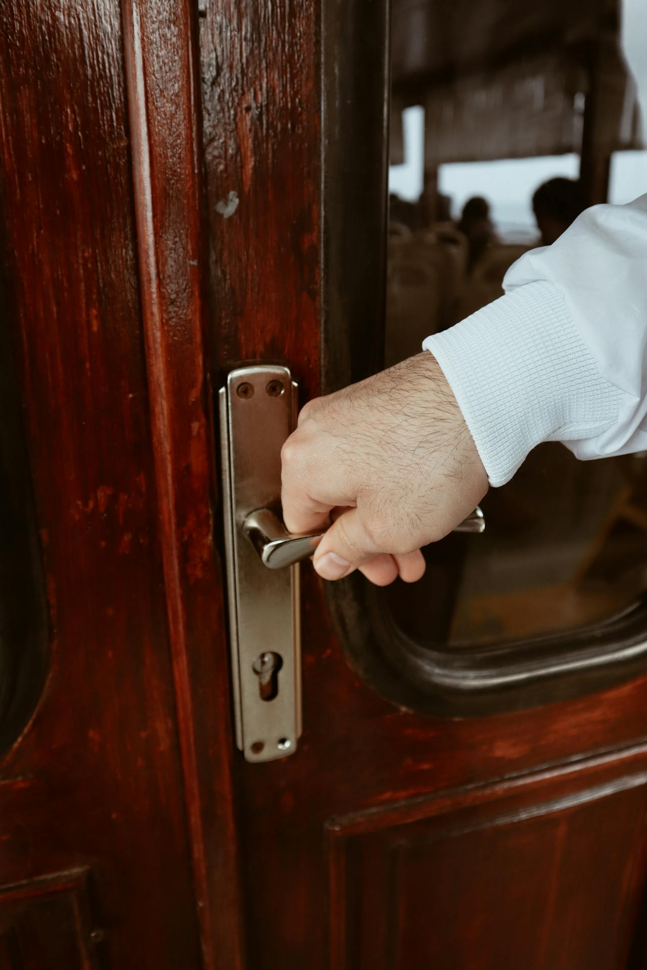 Primer plano de un hombre sujetando el picaporte de una puerta | Fuente: Pexels