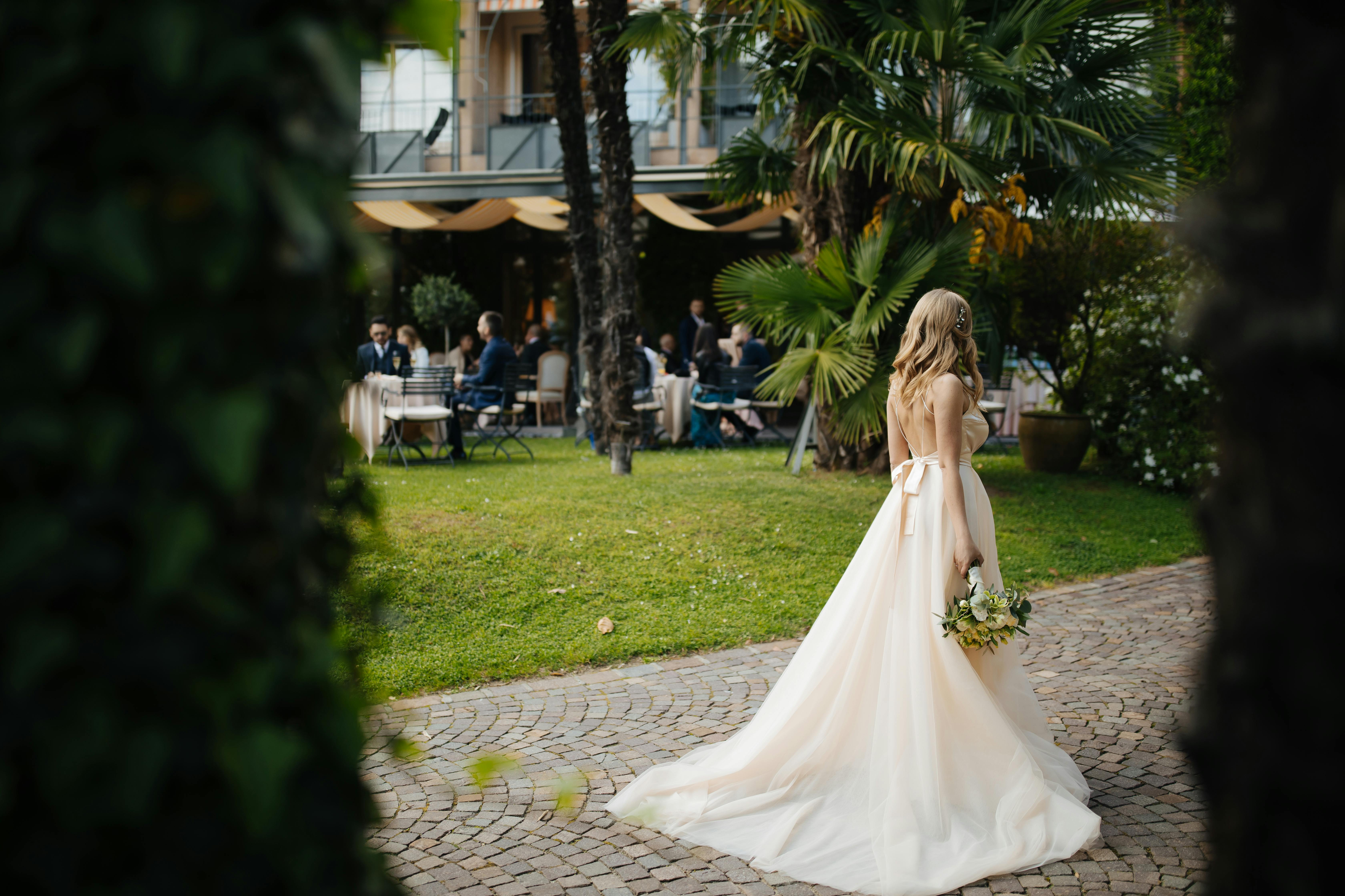 Una novia con un ramo en la mano y caminando sola el día de su boda | Fuente: Pexels