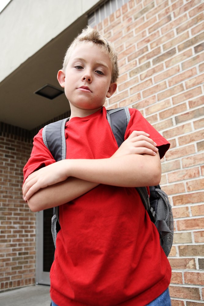 Niño con una camiseta roja, cruzado de brazos. | Foto: Shutterstock