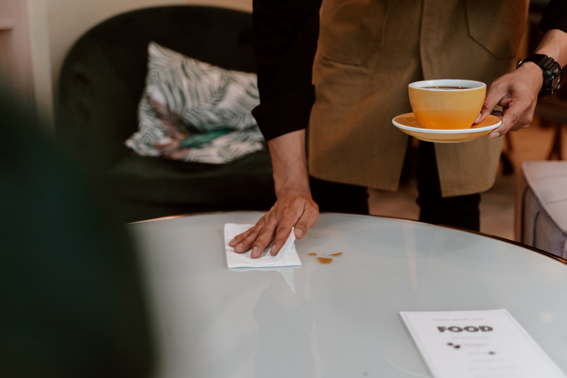 Una persona limpiando una mesa | Fuente: Pexels