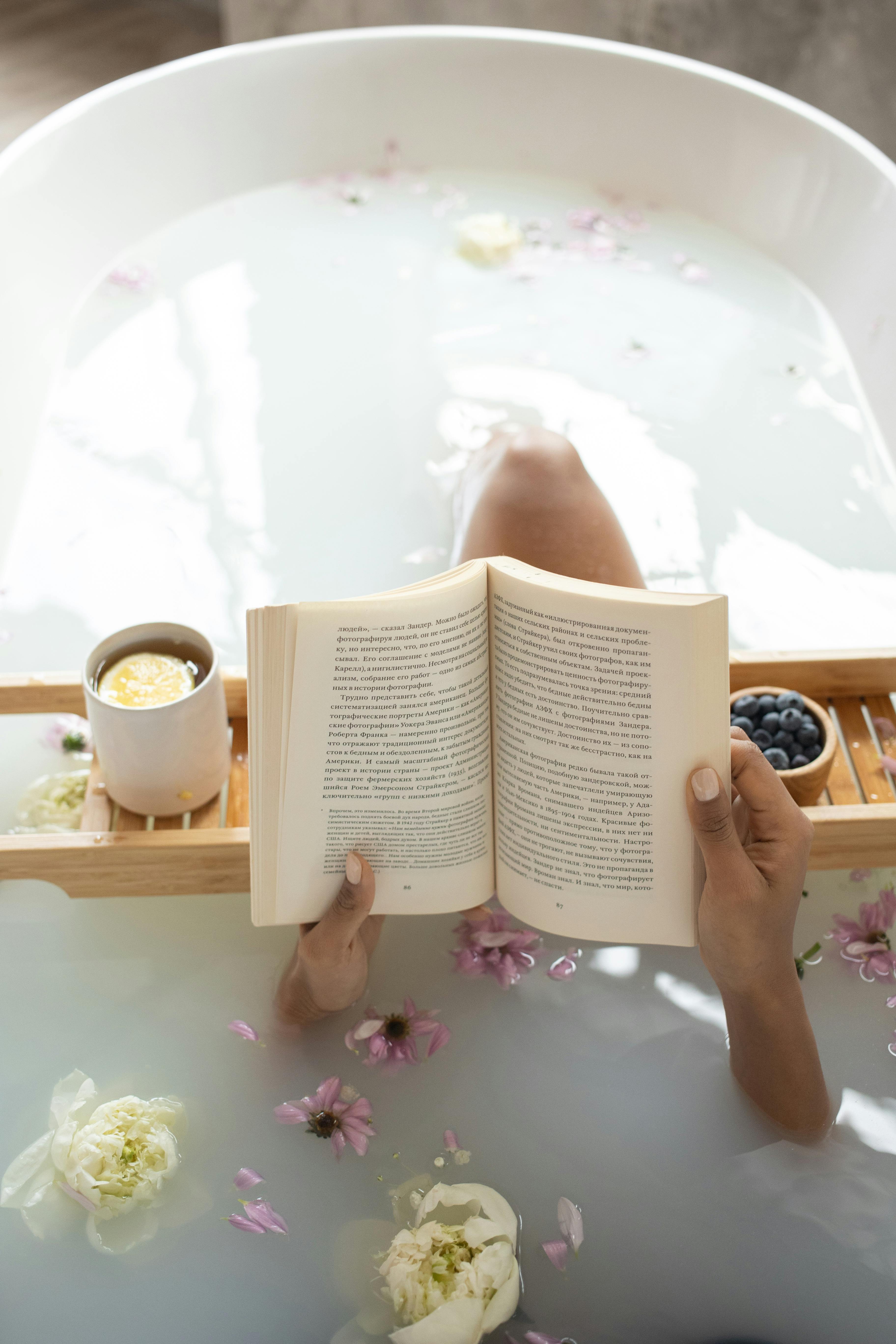 Una mujer leyendo un libro en una bañera durante un tratamiento de spa | Fuente: Pexels