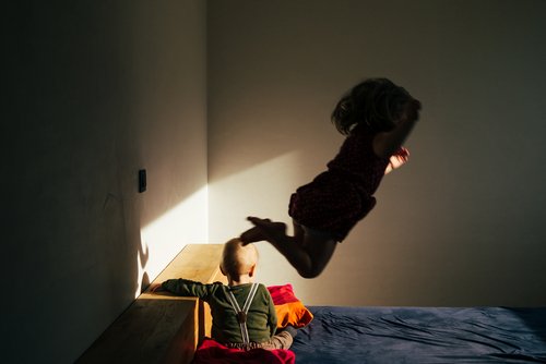 Niños pequeños jugando en la cama. Fuente: Shutterstock