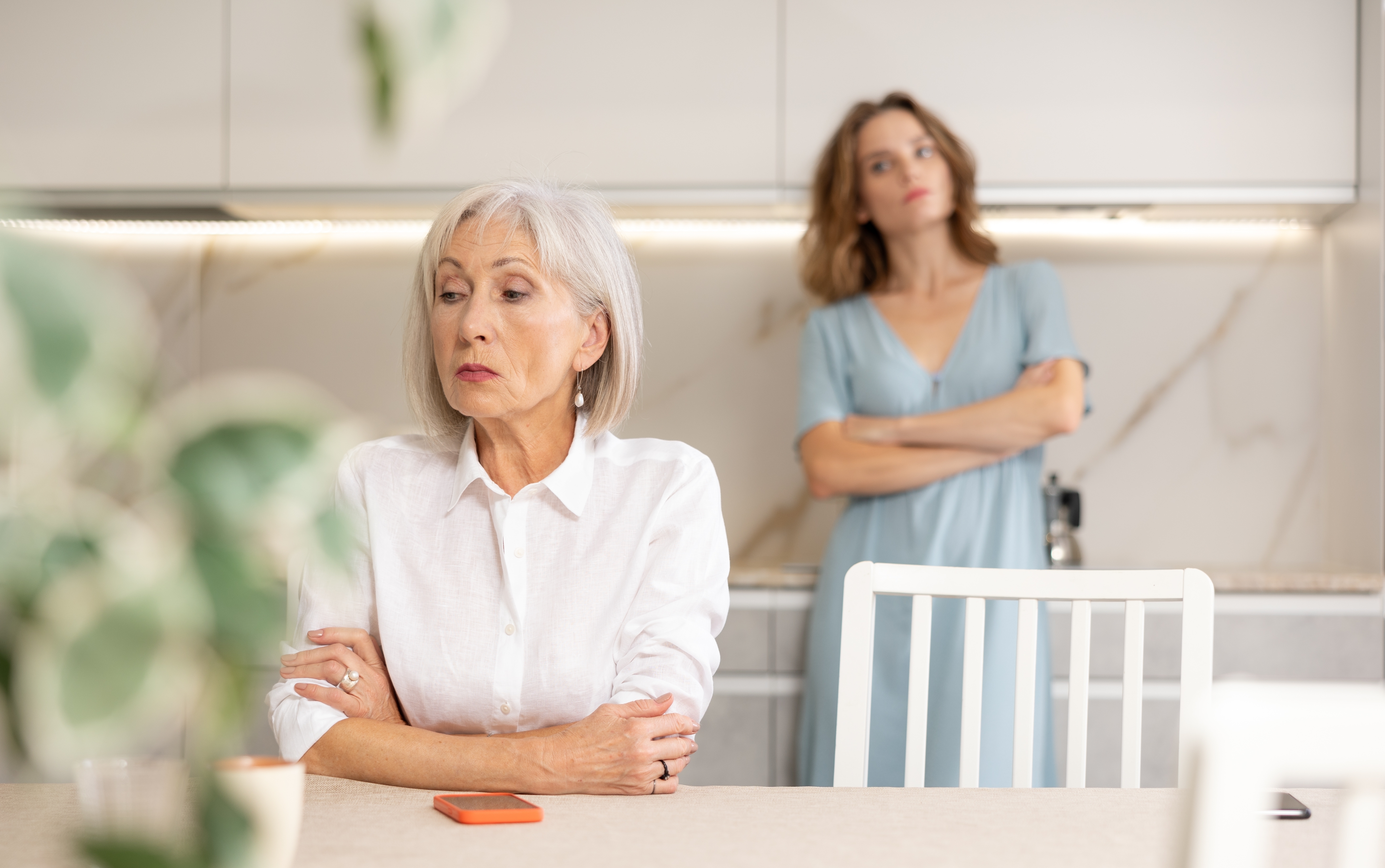 Una mujer mayor sentada con los brazos cruzados tras una discusión con su nuera | Foto: Shutterstock