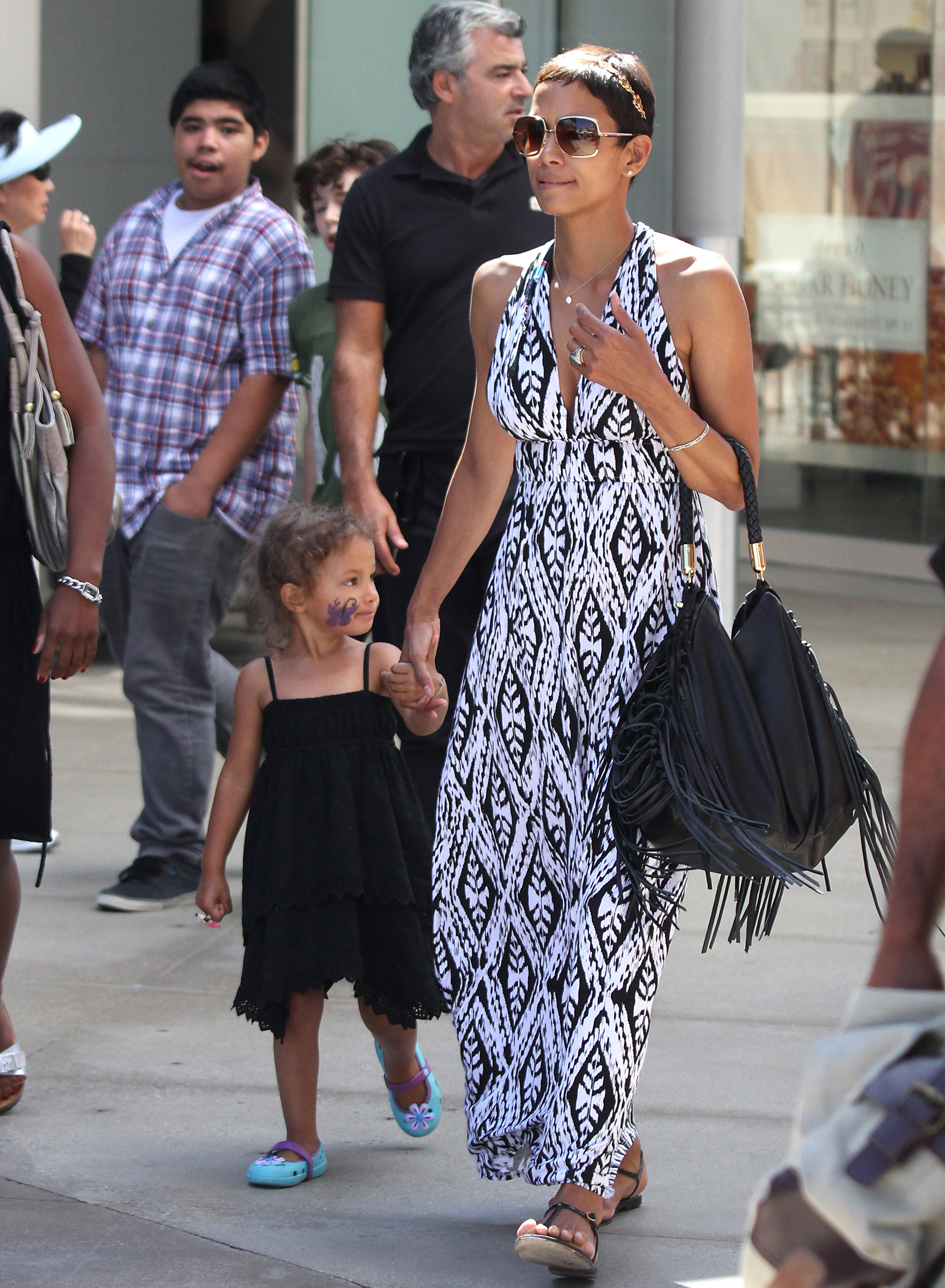 A la pequeña Nahla le habían pintado una mariposa morada en la mejilla mientras paseaba de la mano con Halle Berry durante una salida de compras. | Fuente: Getty Images.