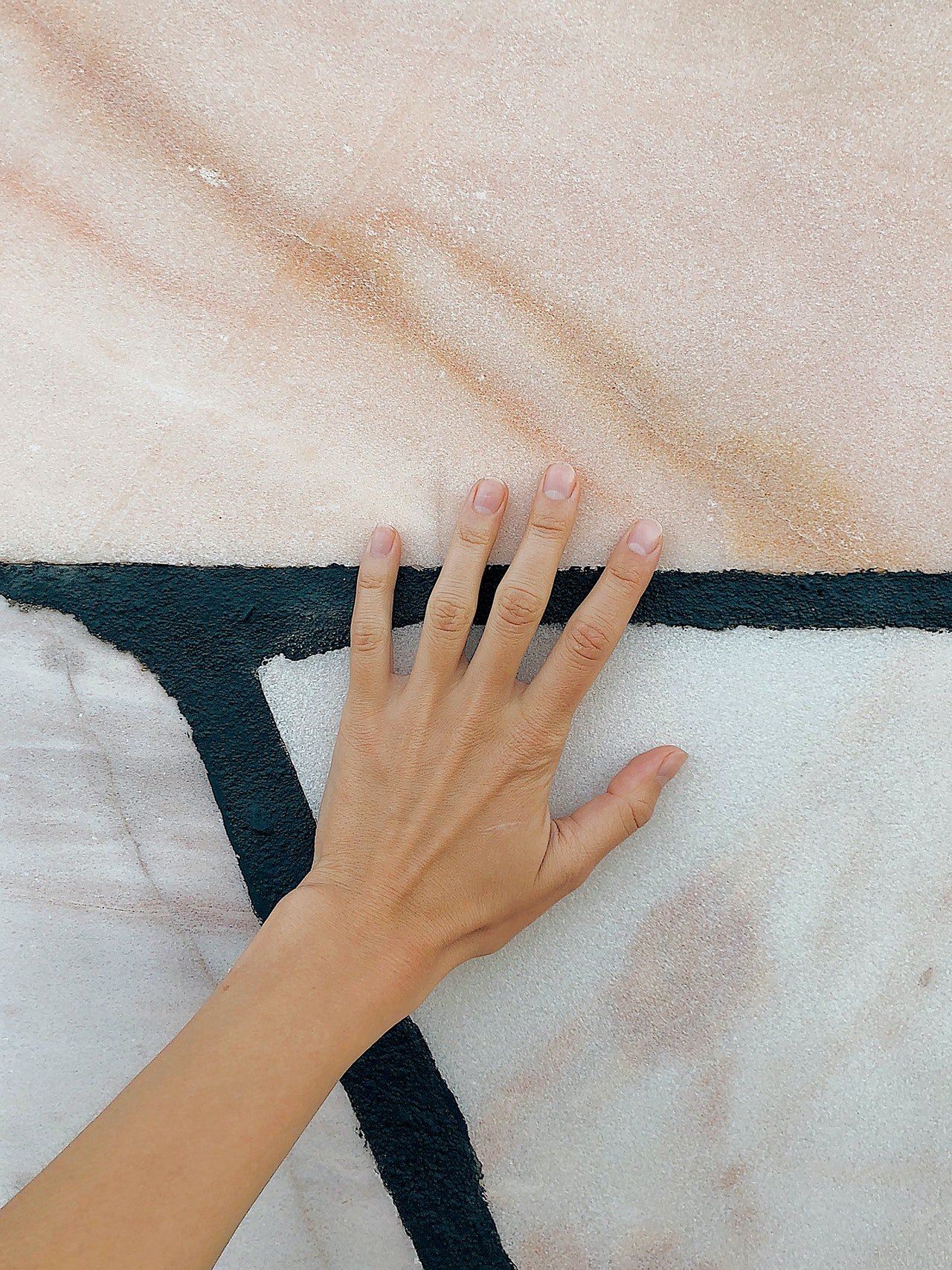 Una mano femenina sobre una pared. | Foto: Pexels