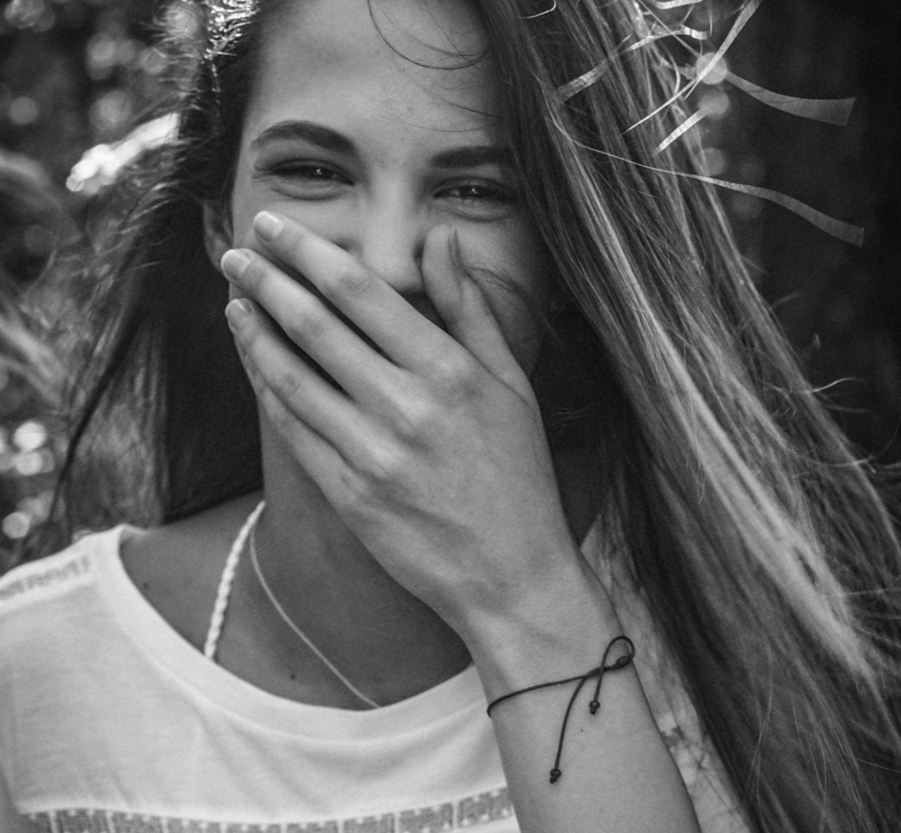 Mujer feliz tapándose la boca | Fuente: Pexels