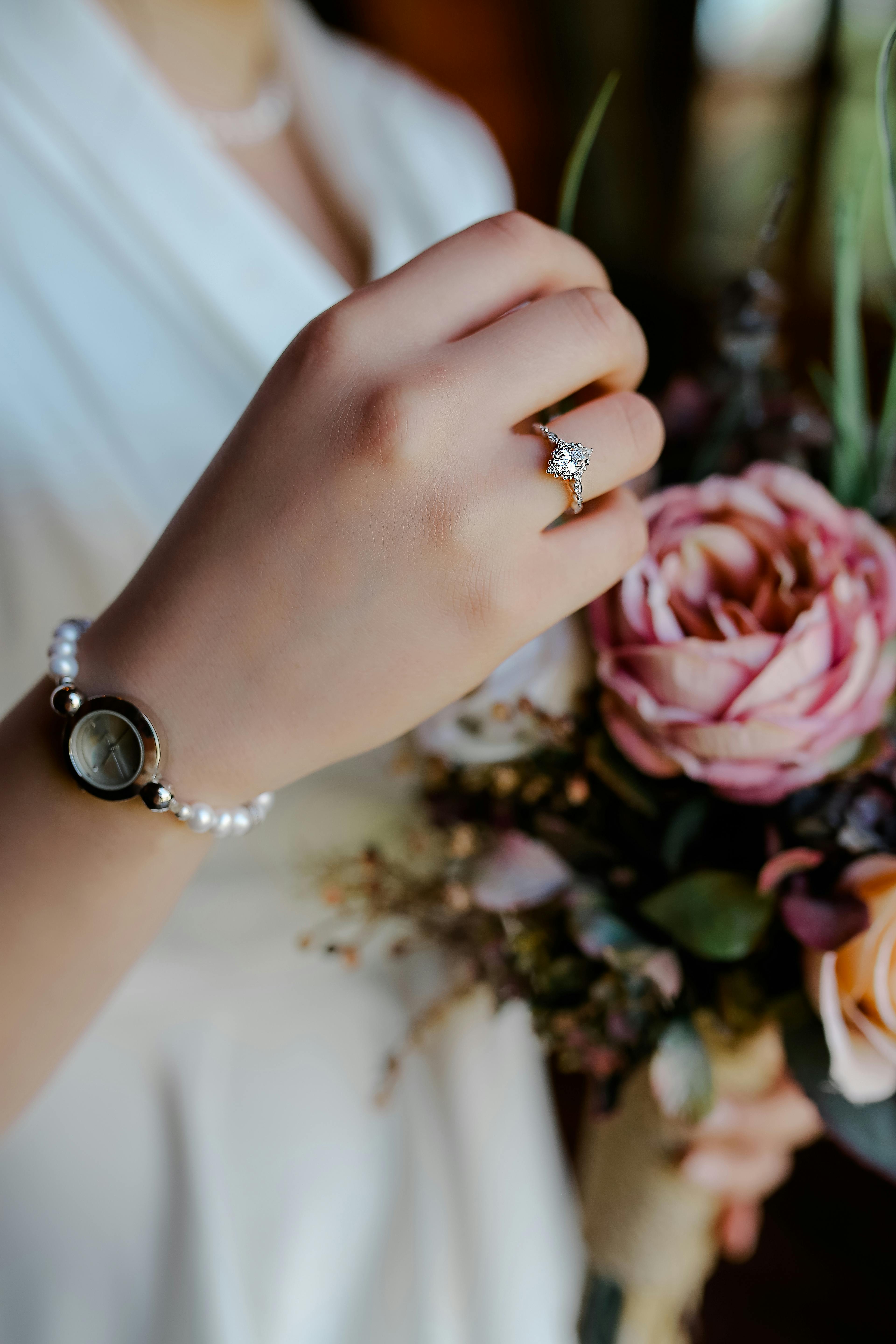 Una mujer con un ramo en la mano y un anillo de diamantes | Fuente: Pexels