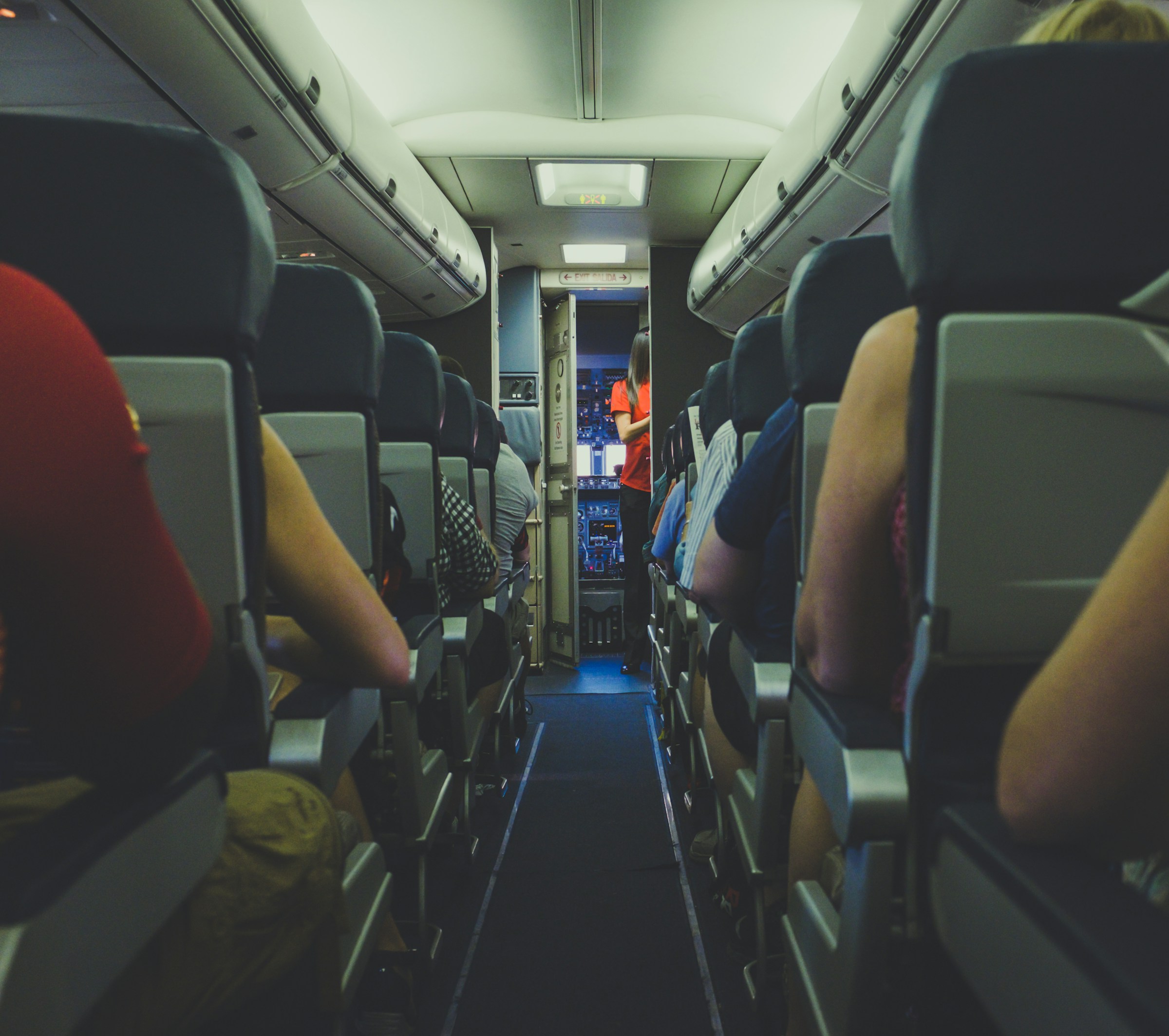 Una azafata y gente en un avión | Fuente: Unsplash