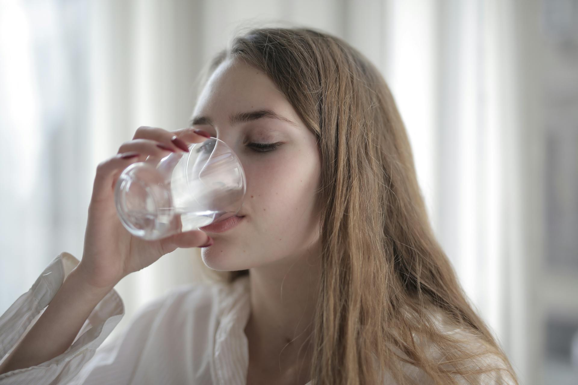 Una mujer bebiendo agua | Fuente: Pexels