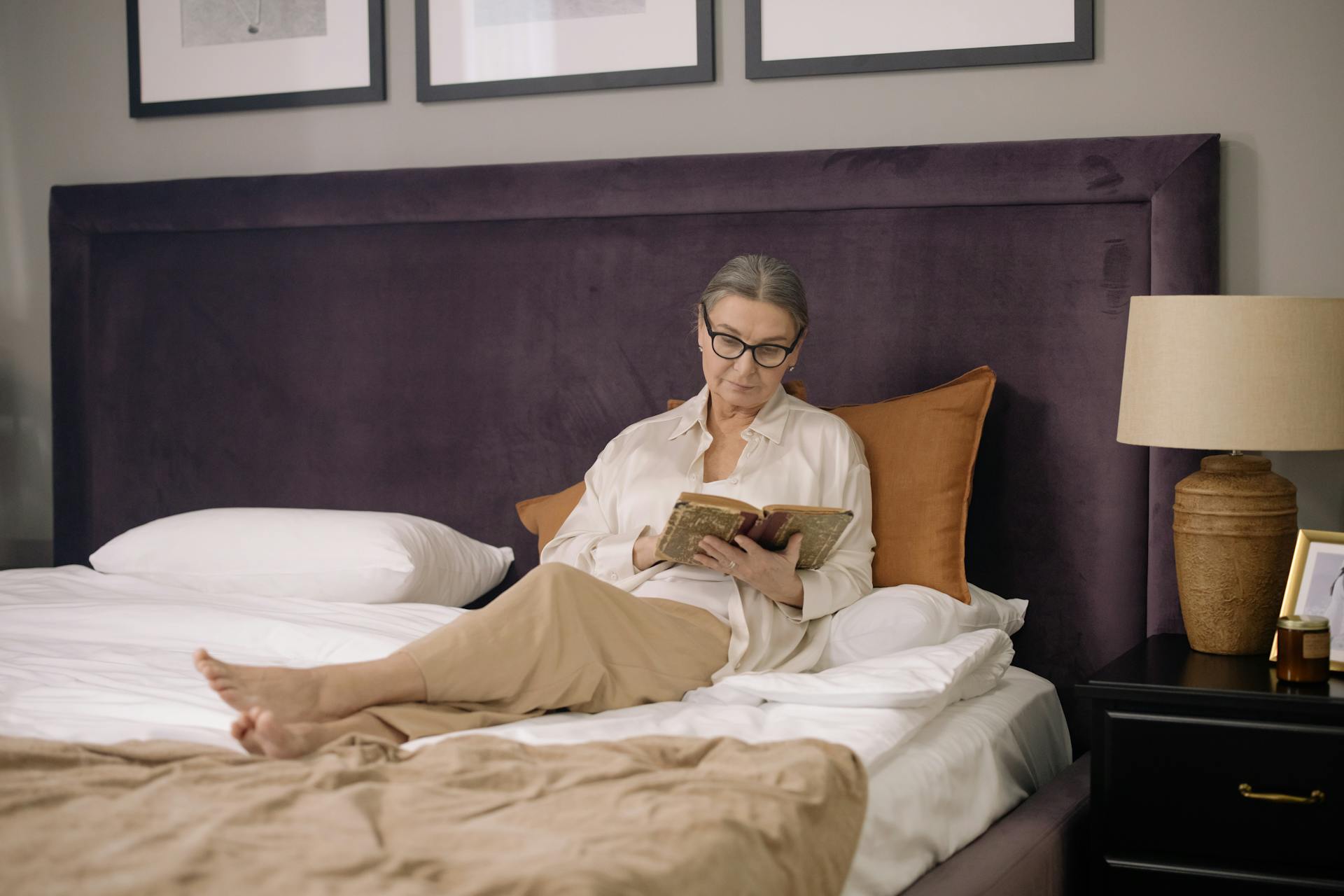Una mujer mayor leyendo en la cama | Fuente: Pexels