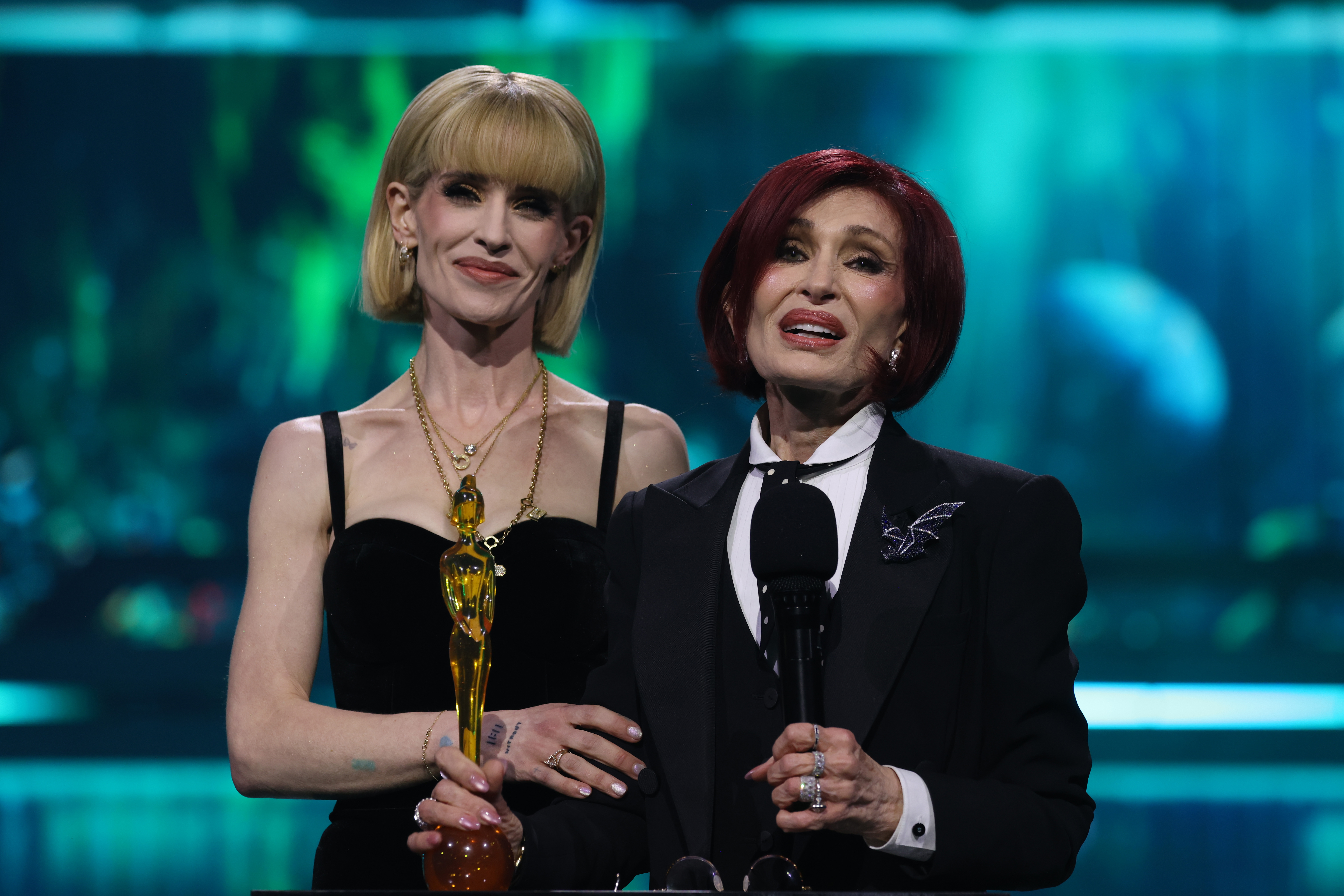 Kelly Osbourne estaba junto a su madre, Sharon, mientras recogían el Premio a toda una carrera, otorgado a título póstumo a Ozzy Osbourne, en los BRIT Awards de 2026, en homenaje a la fallecida leyenda del rock tan solo siete meses después de su muerte. | Fuente: Getty Images.