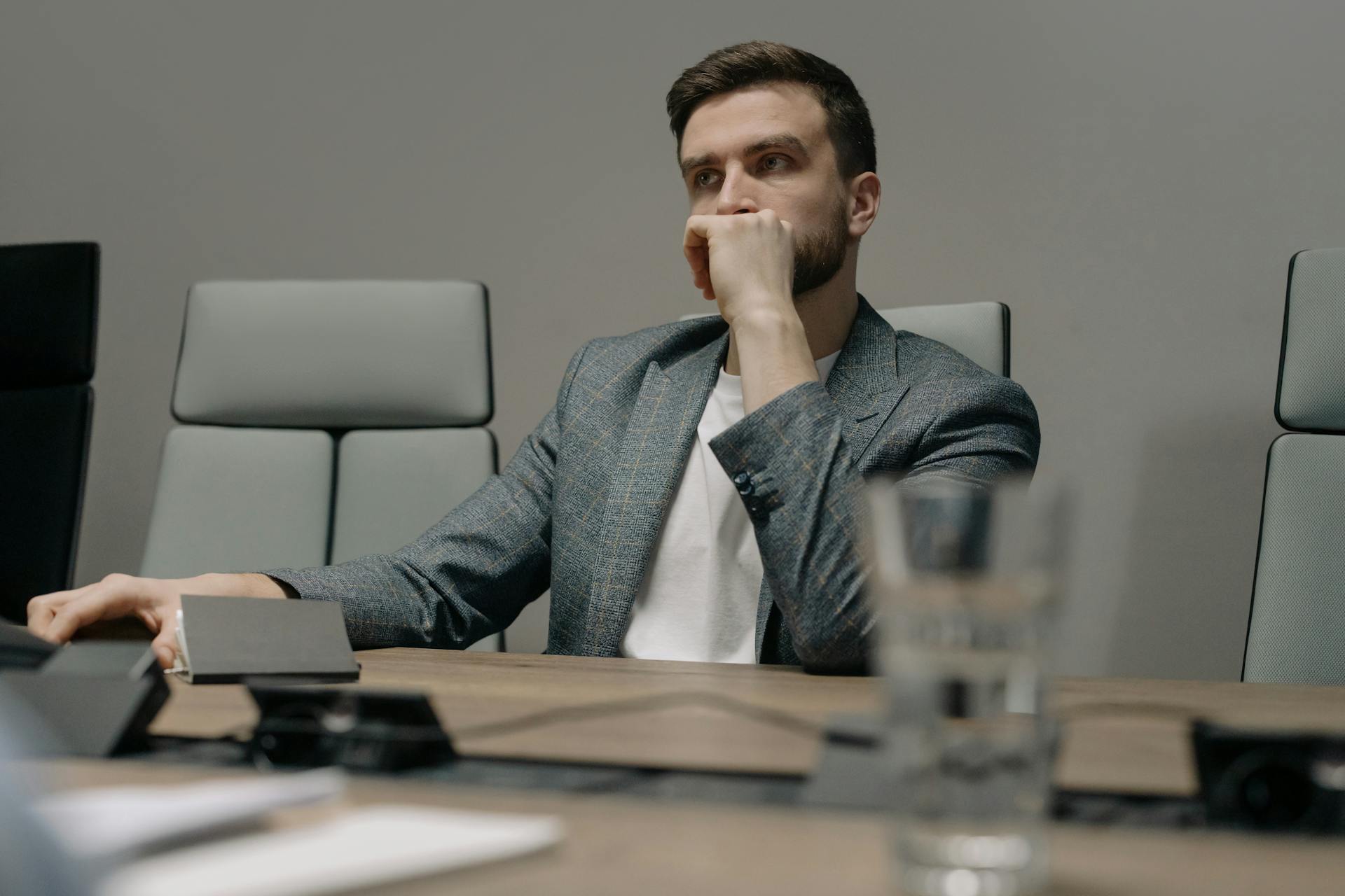 Un hombre parece pensativo sentado en su despacho | Fuente: Pexels