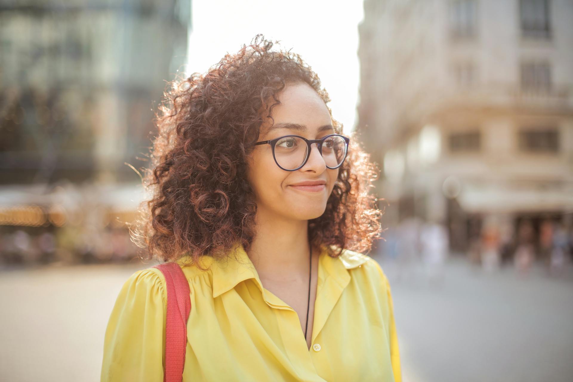 Una mujer en una acera sonriendo a alguien | Fuente: Pexels