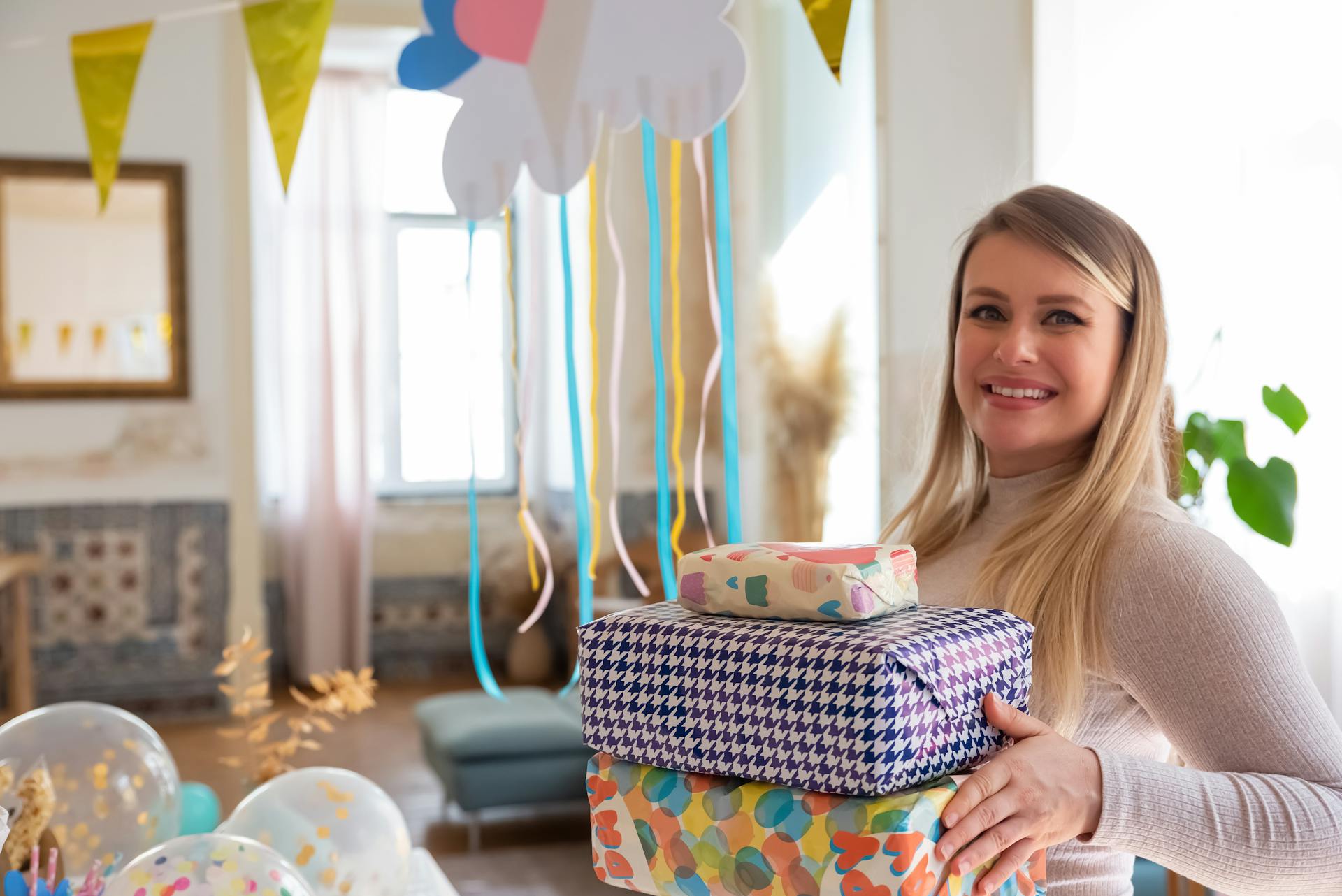 Una mujer sosteniendo una pila de regalos durante un baby shower | Fuente: Pexels