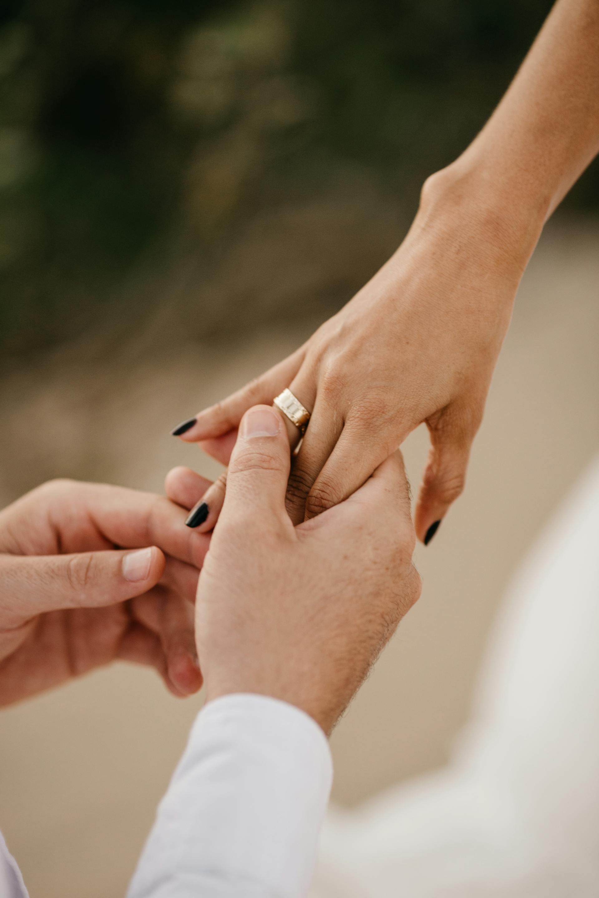 Un hombre deslizando un anillo de compromiso en el dedo de una mujer | Fuente: Pexels