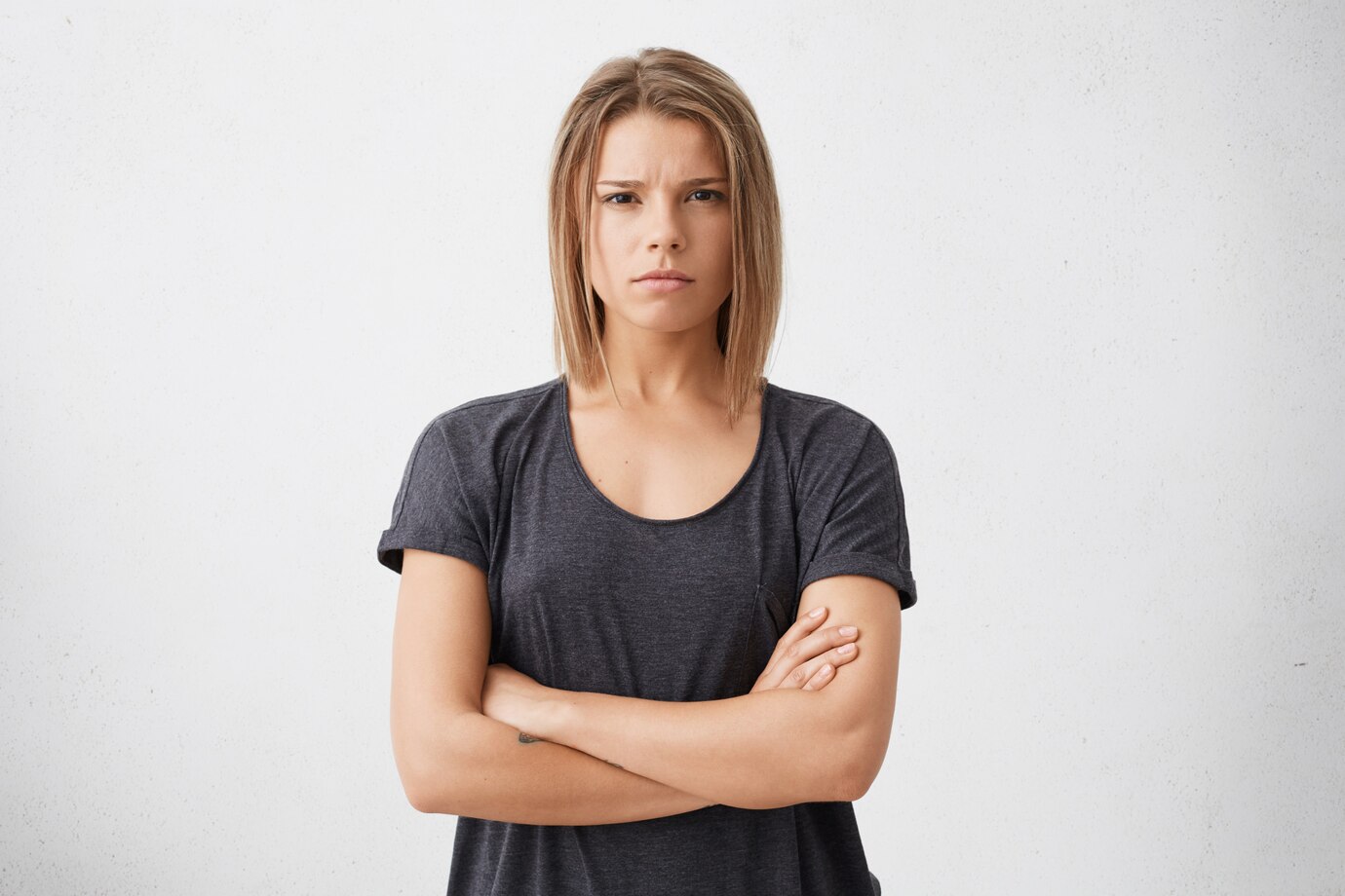Una mujer seria con los brazos cruzados | Fuente: Freepik