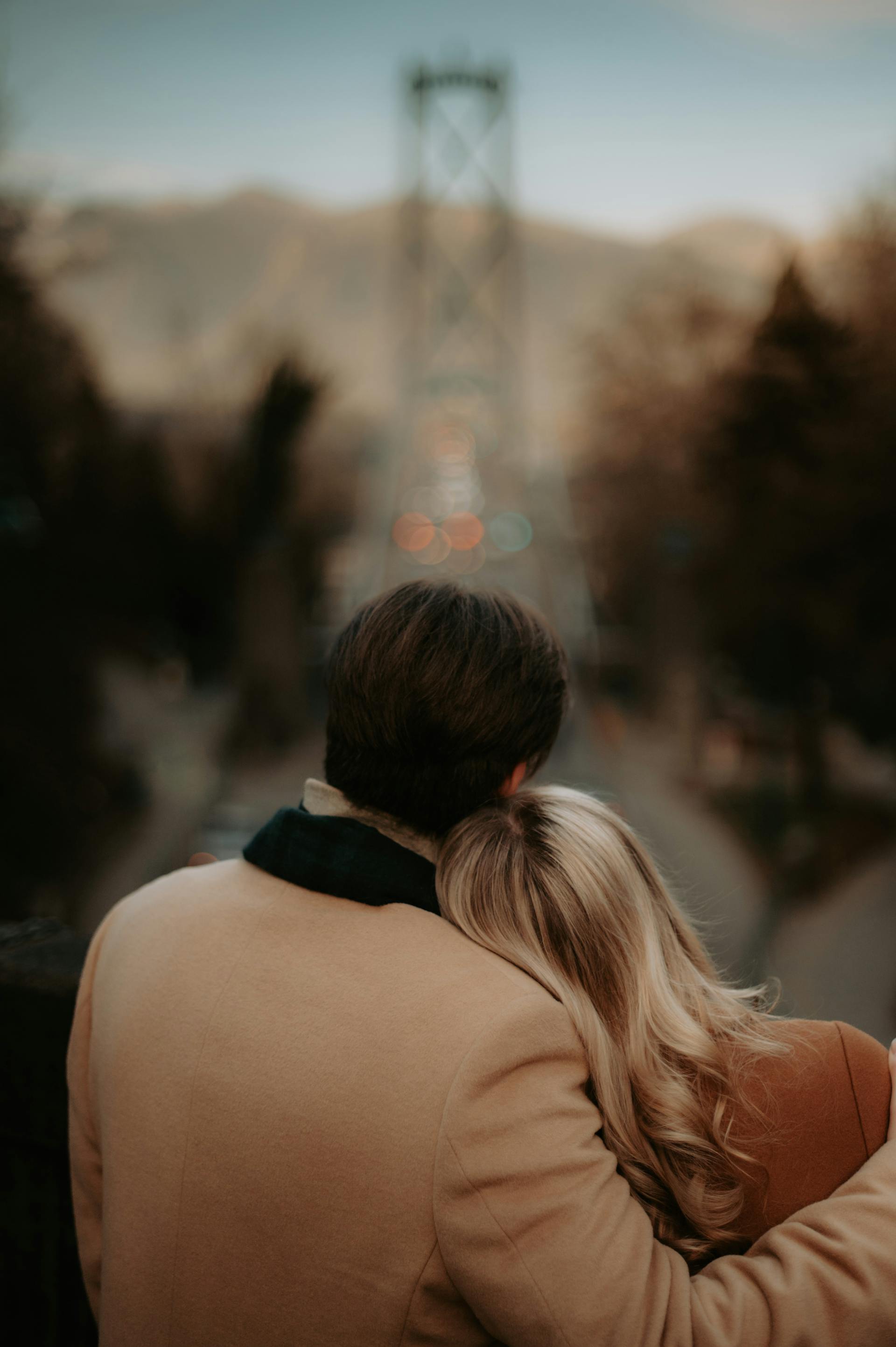 Un hombre abrazando a una mujer contra un paisaje urbano borroso | Fuente: Pexels