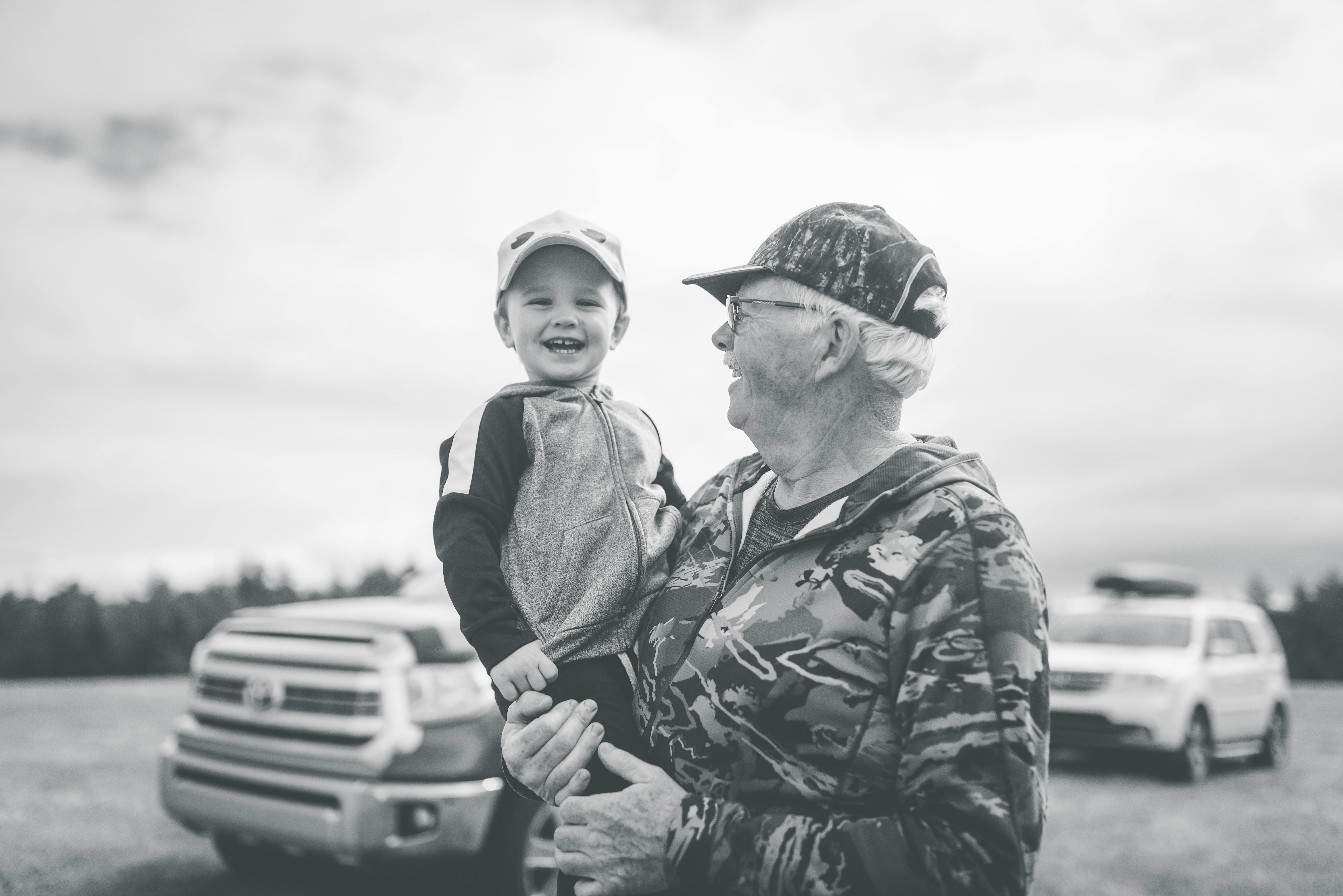 Un anciano feliz con un niño en brazos | Fuente: Pexels