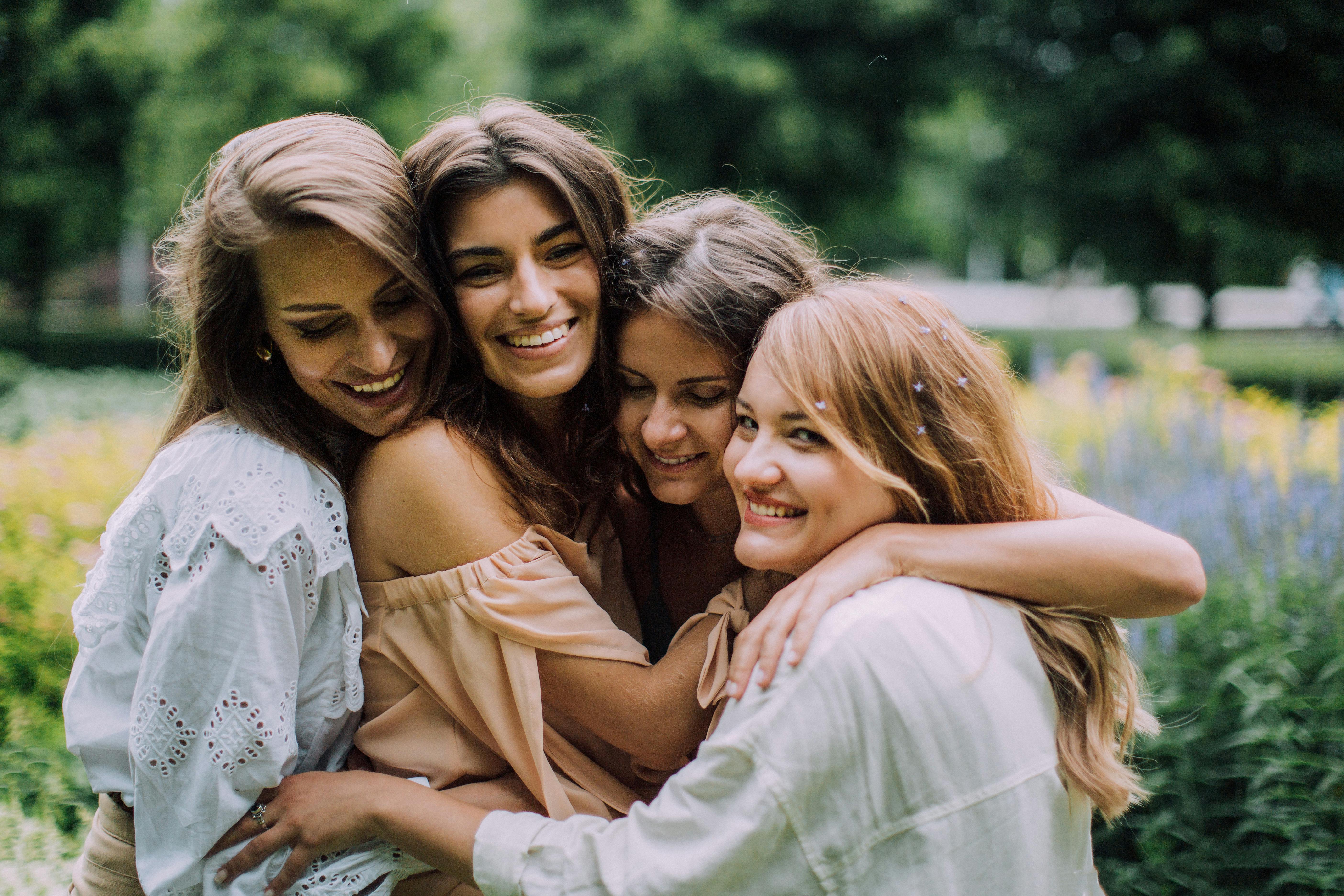Un grupo de amigas sonriendo y abrazándose | Fuente: Pexels