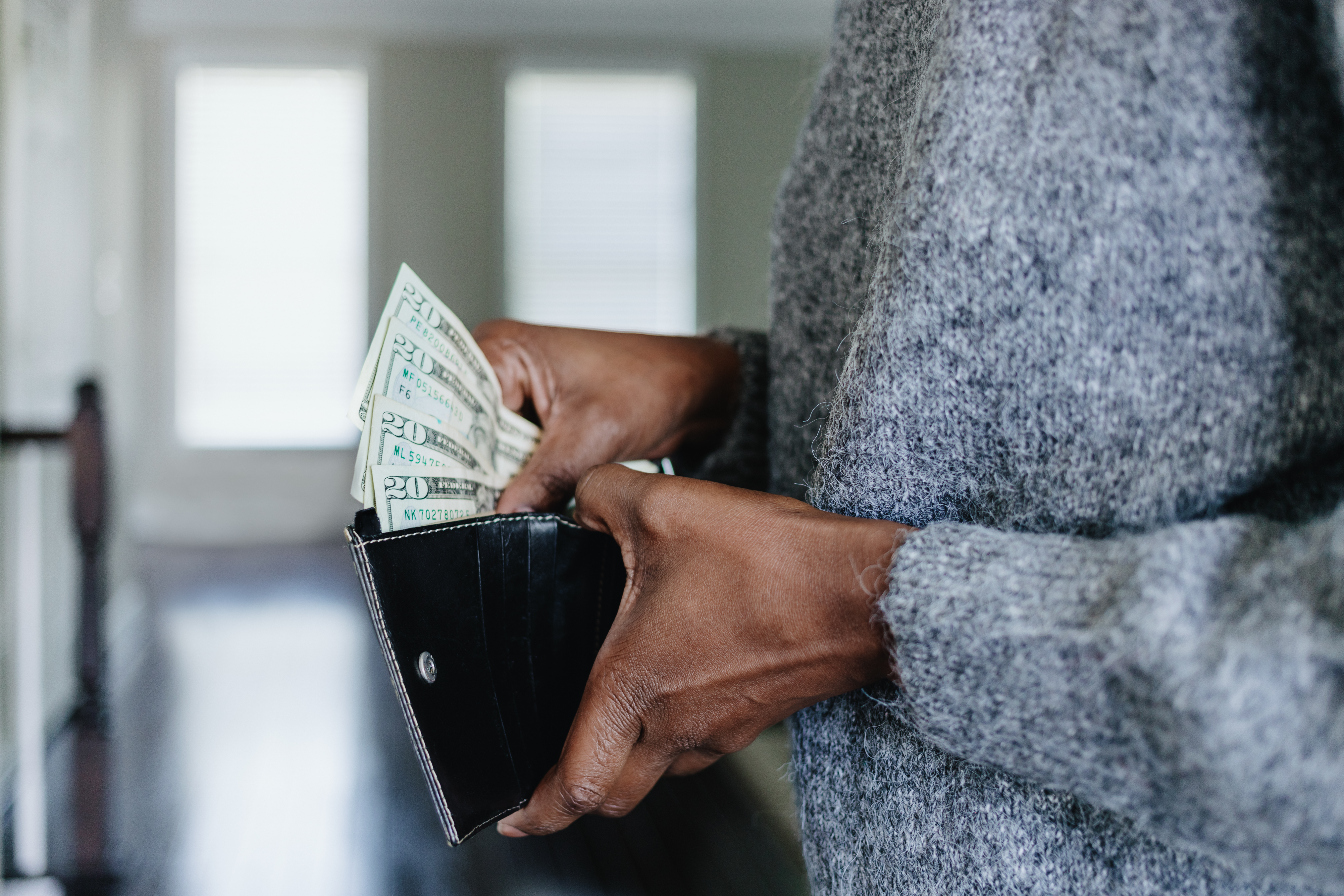 Mujer metiendo dinero en la cartera | Foto: Getty Images