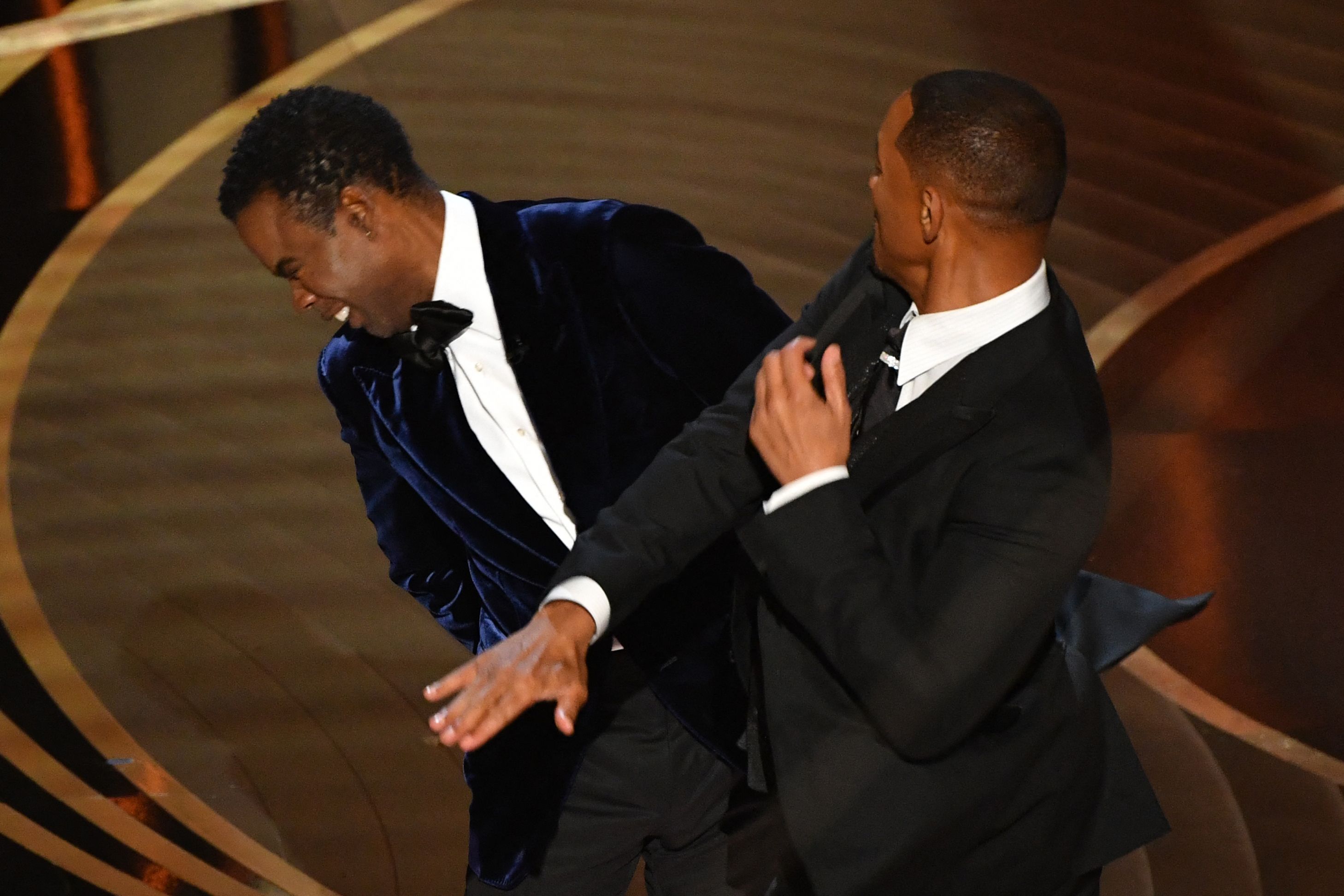 El actor estadounidense Will Smith (d) abofetea al actor estadounidense Chris Rock en el escenario durante la 94ª edición de los Oscar en el Dolby Theatre de Hollywood, California, el 27 de marzo de 2022 | Fuente: Getty Images