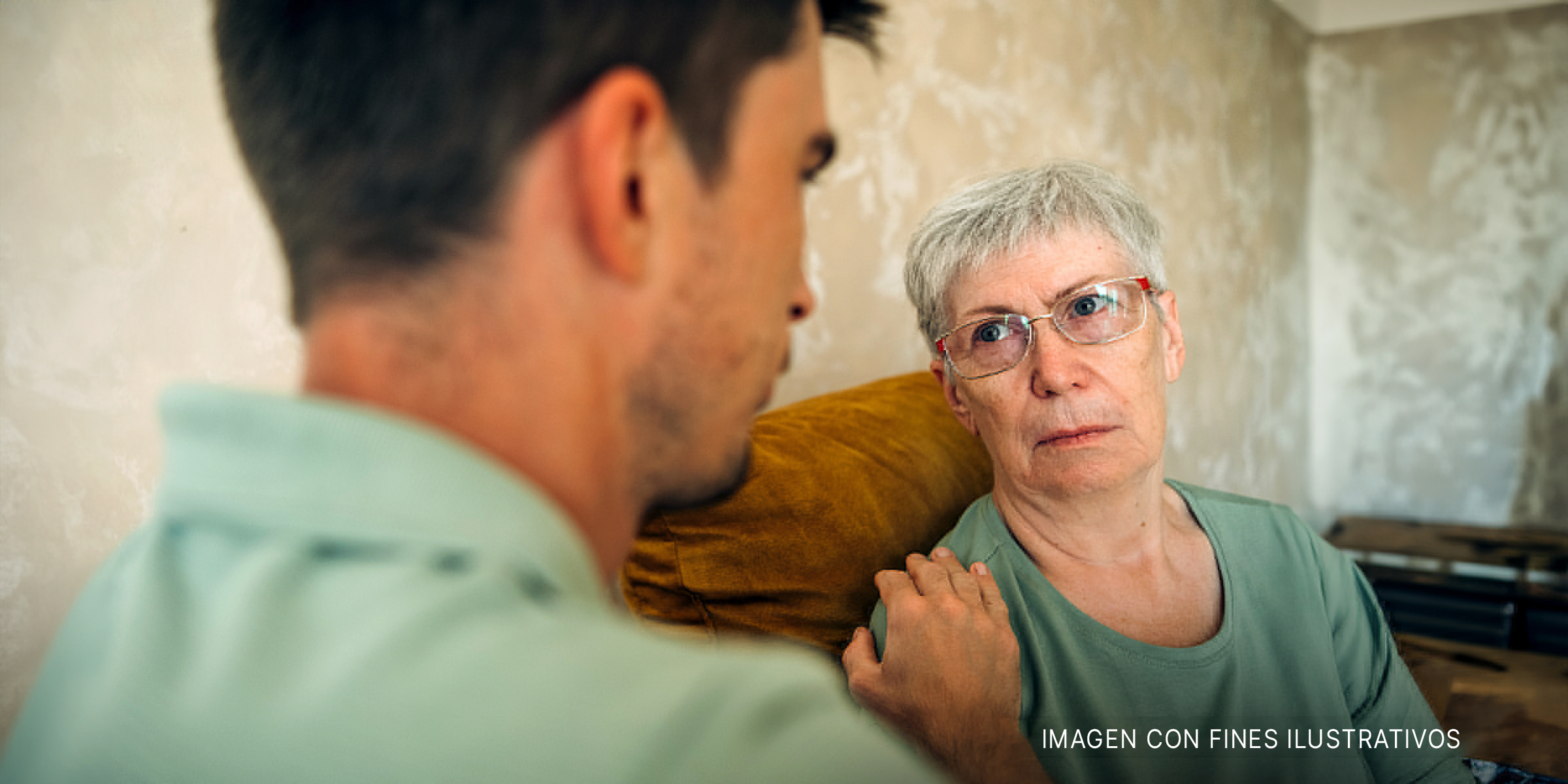 Hombre consuela a una anciana | Foto: Shutterstock