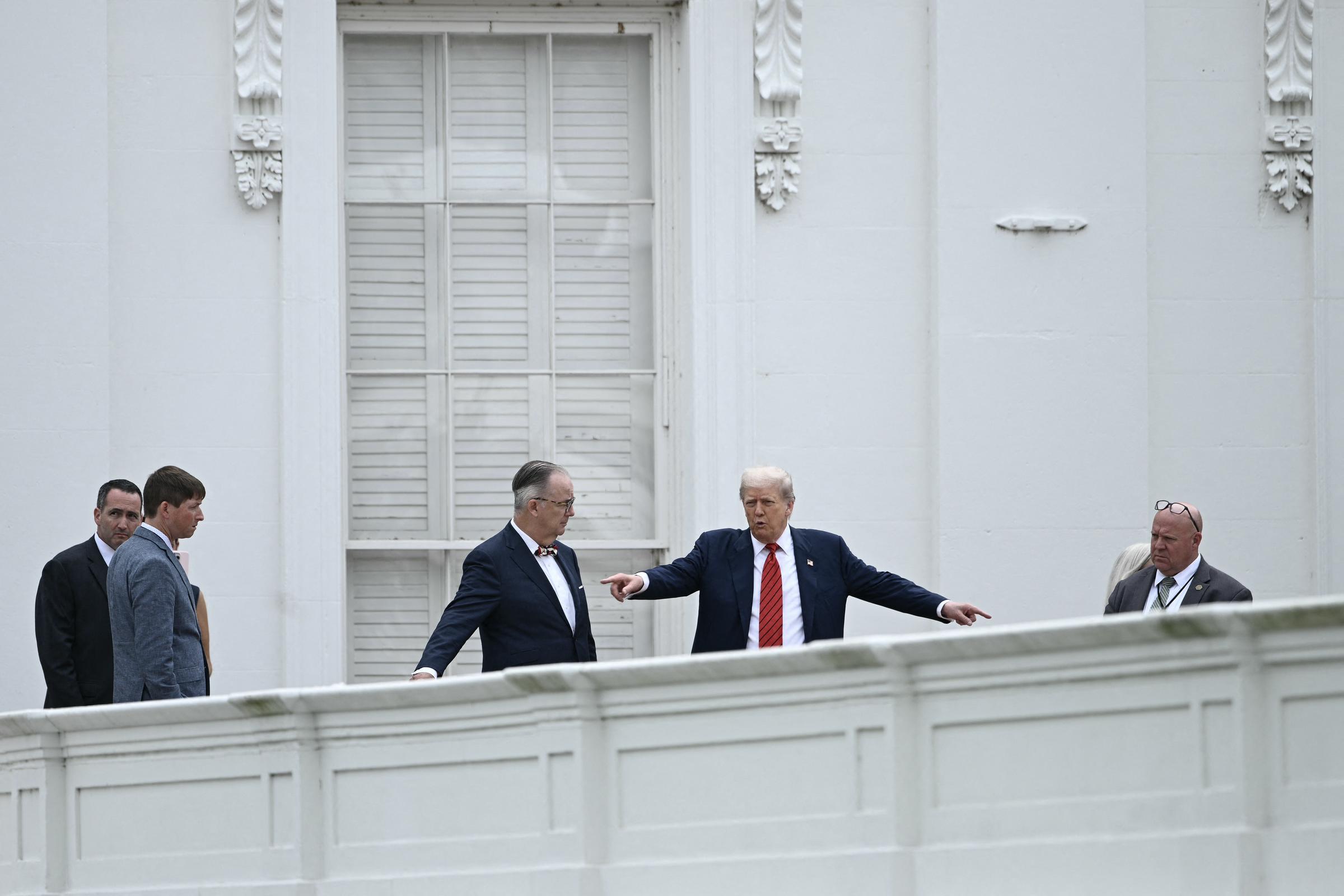 Donald Trump habla con el arquitecto James C. McCrery mientras recorre el techo del ala oeste de la Casa Blanca en Washington, D.C., señalando detalles mientras la seguridad y el personal observan.