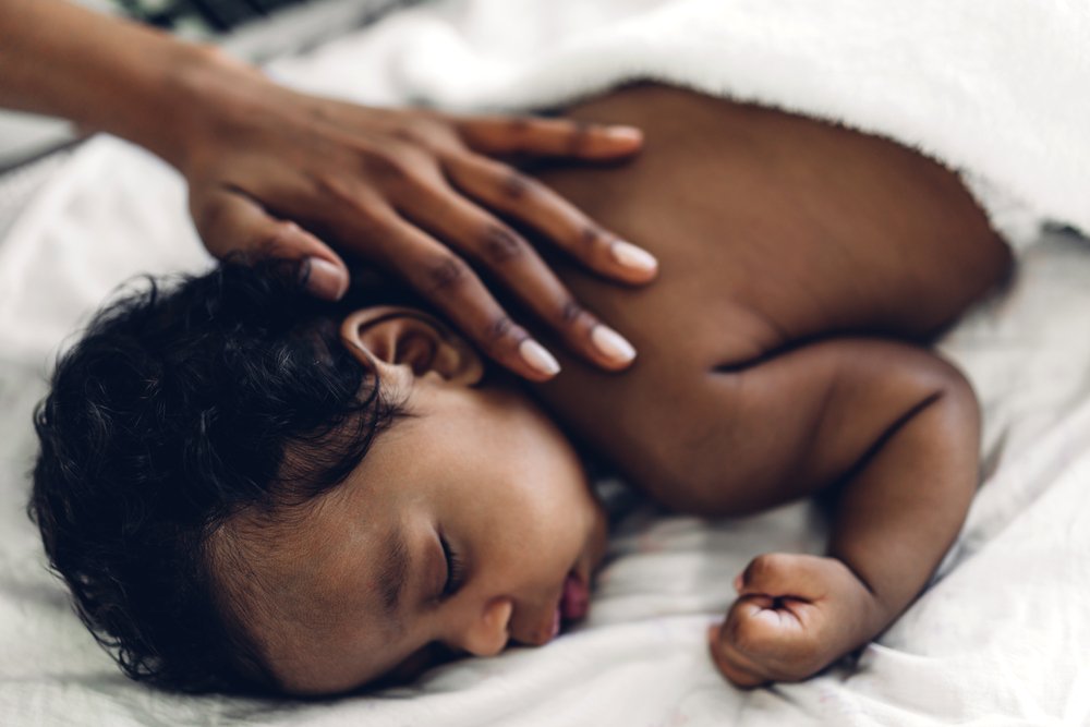 Bebé afroaméricano durmiendo bajo el cuidado de su abuela. | Foto: Shutterstock.