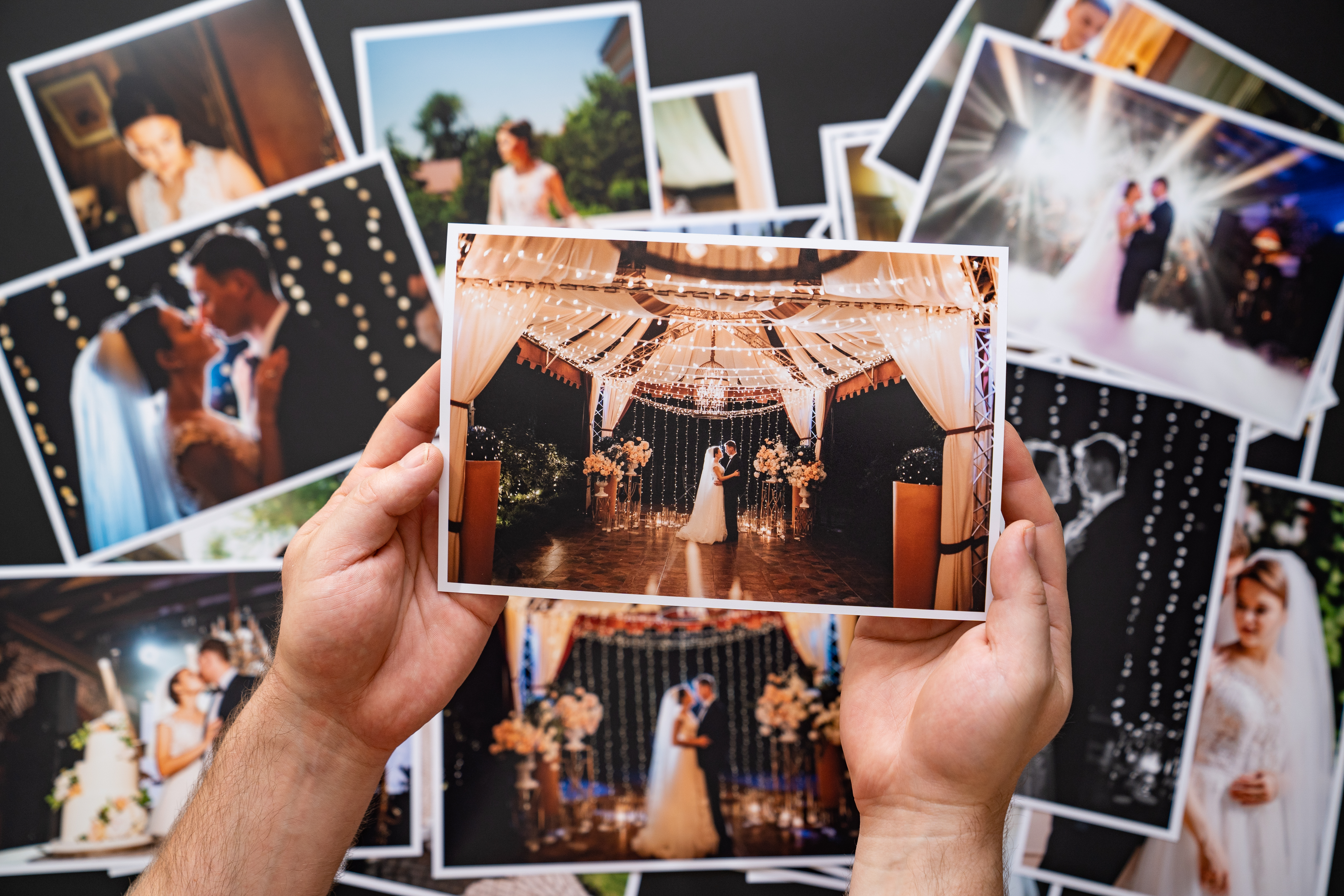 Las manos extienden una copia impresa de las fotos de la boda | Fuente: Shutterstock