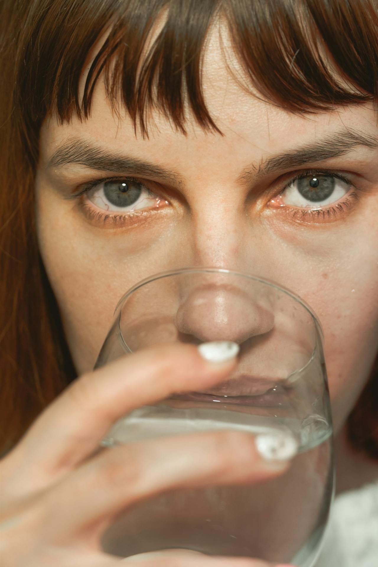 Una mujer bebiendo un vaso de agua | Fuente: Pexels
