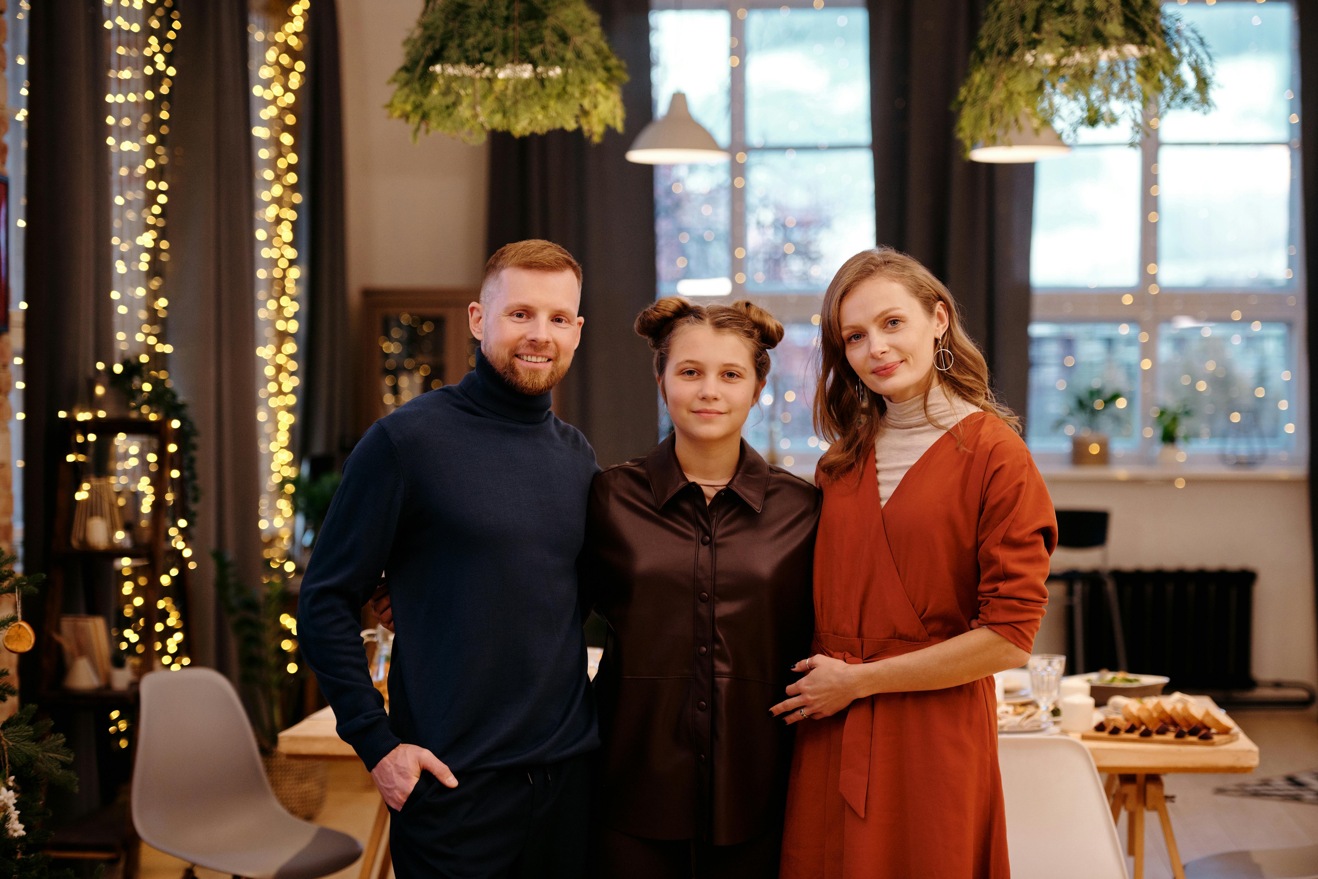 Una feliz familia de tres con un hombre, una mujer joven y una mujer mayor posando juntos | Fuente: Pexels