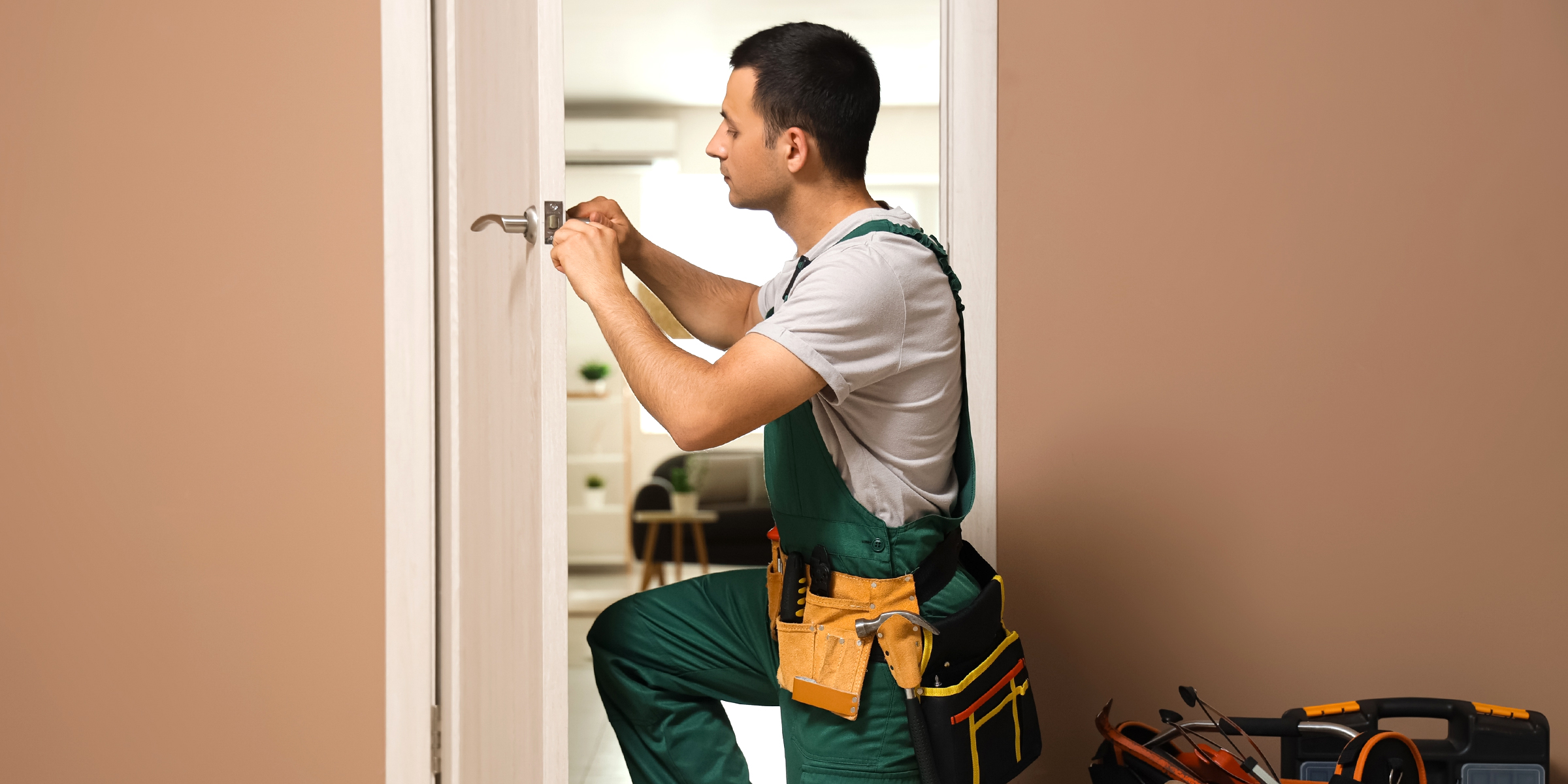 Una persona arreglando la cerradura de una puerta | Fuente: Shutterstock