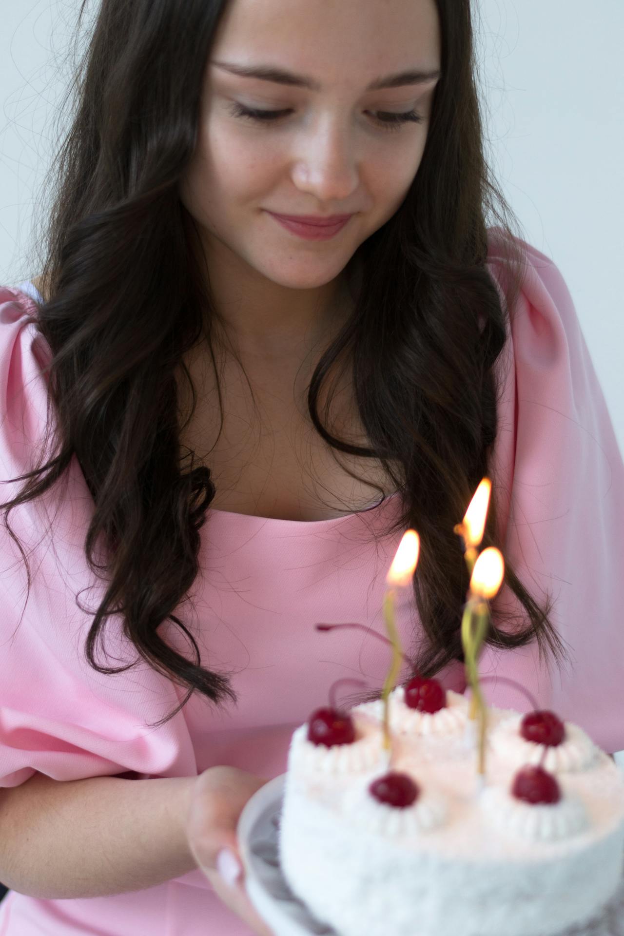 Una giovane donna guarda la sua torta di compleanno | Fonte: Pexels