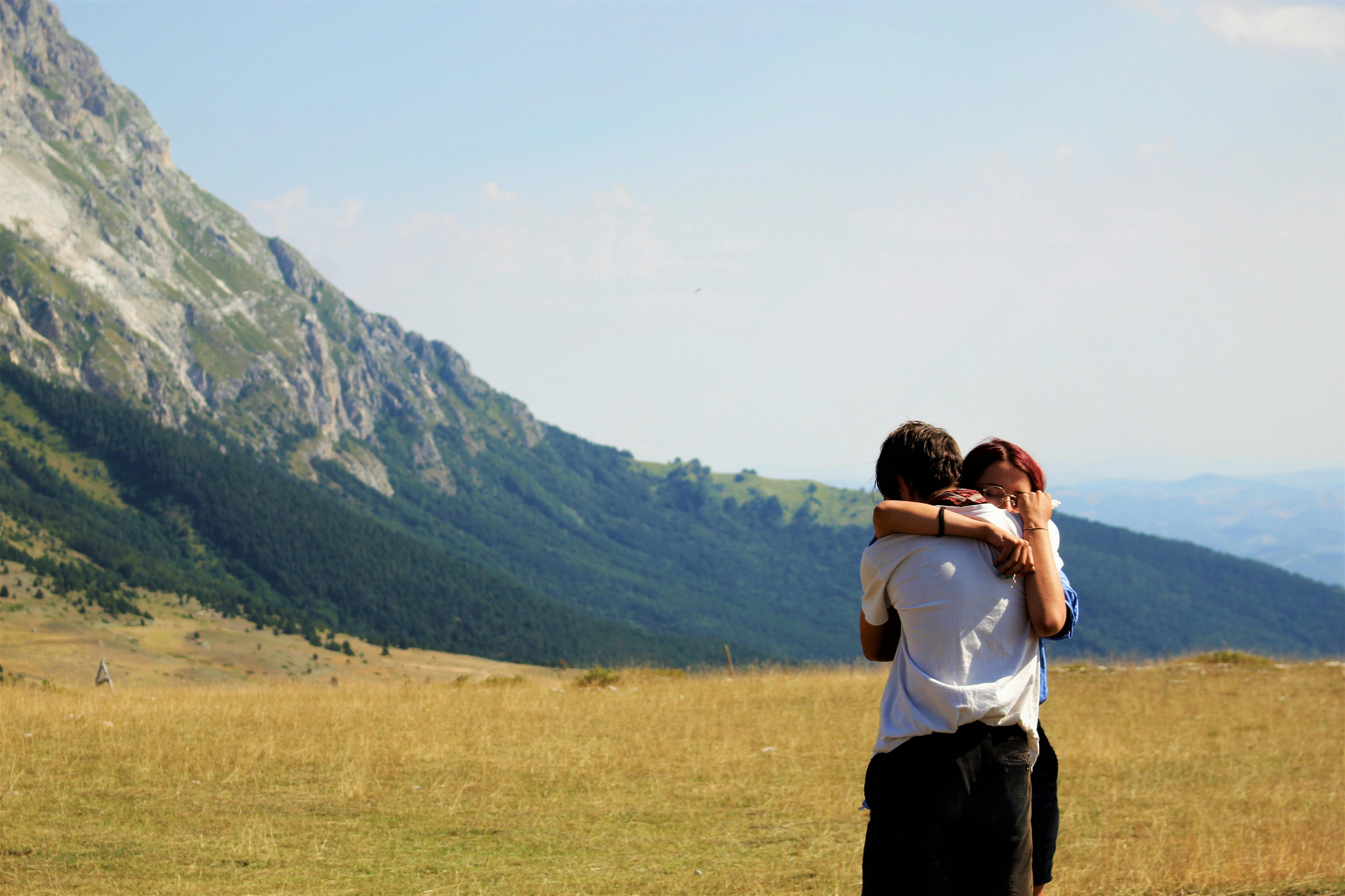 Pareja se abraza en un campo | Foto: Pexels